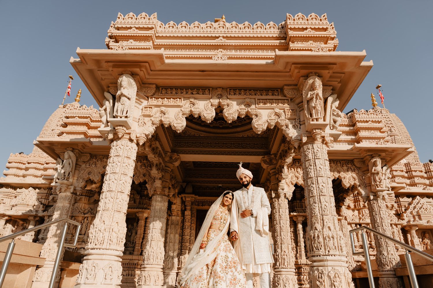 Ornate sandstone temple entrance with detailed carvings and pillars in traditional Indian architectural style.
