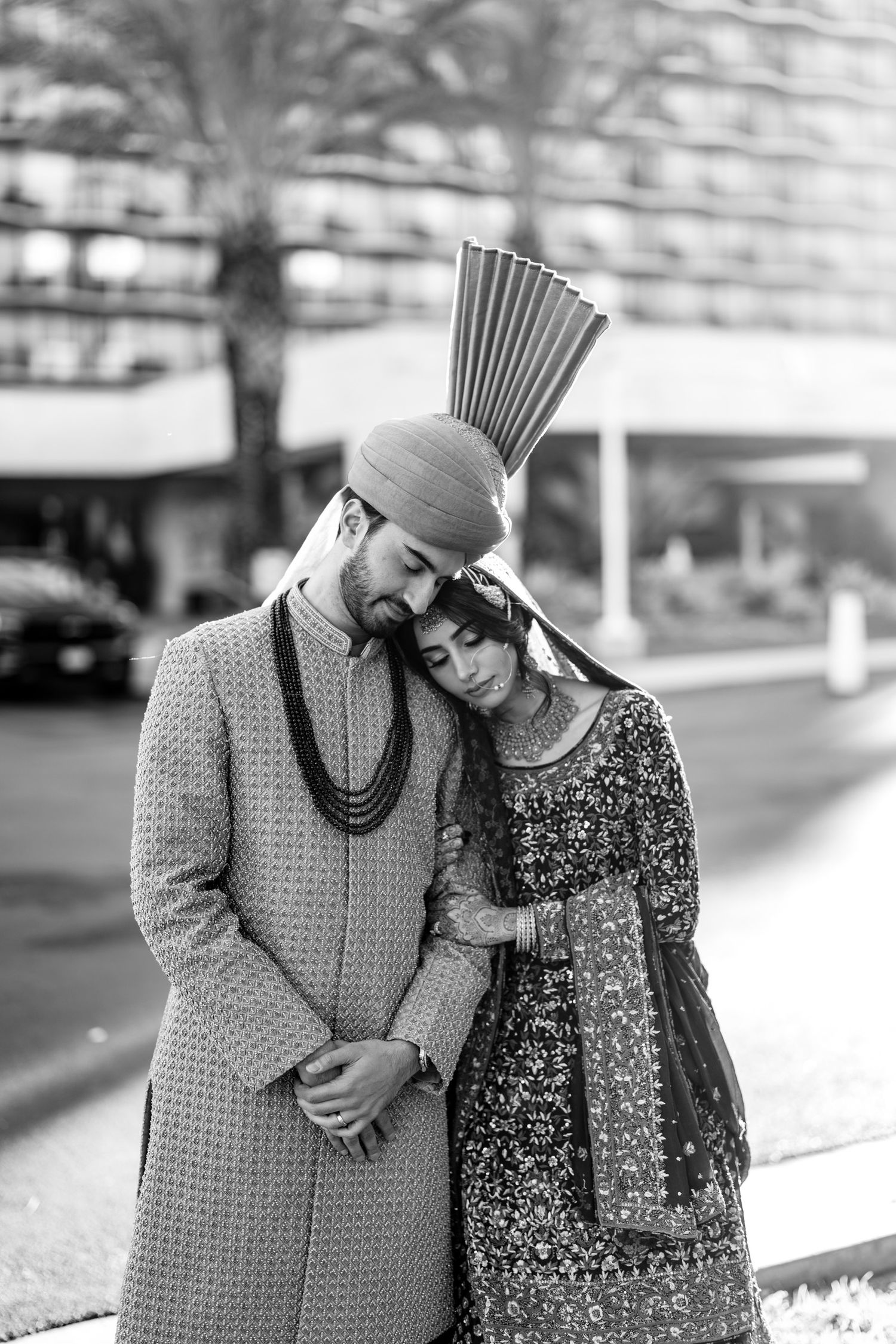Black and white photo series showing a couple in traditional attire embracing outdoors.