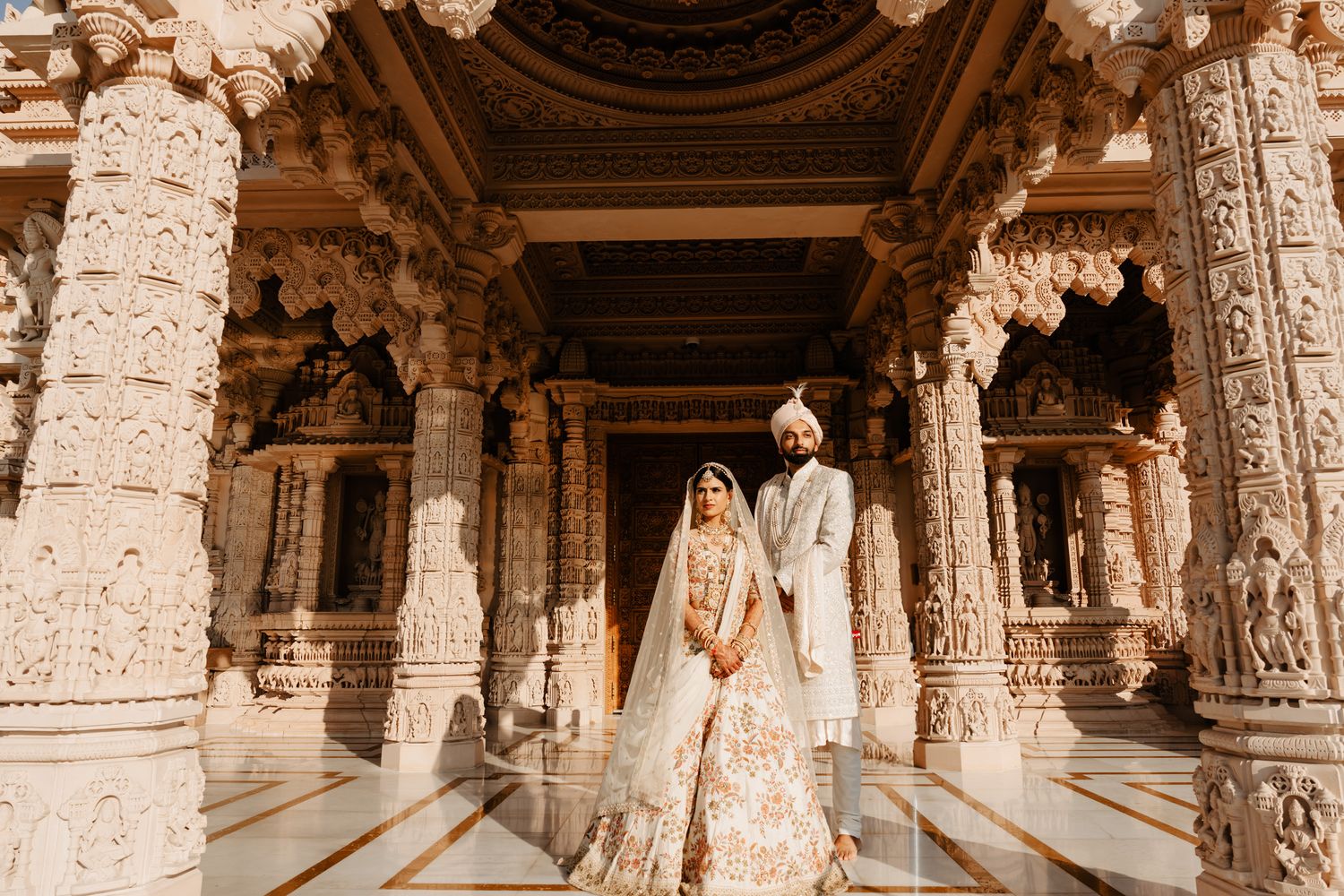 Ancient carved stone pillars and architecture of an Indian temple with ornate details.