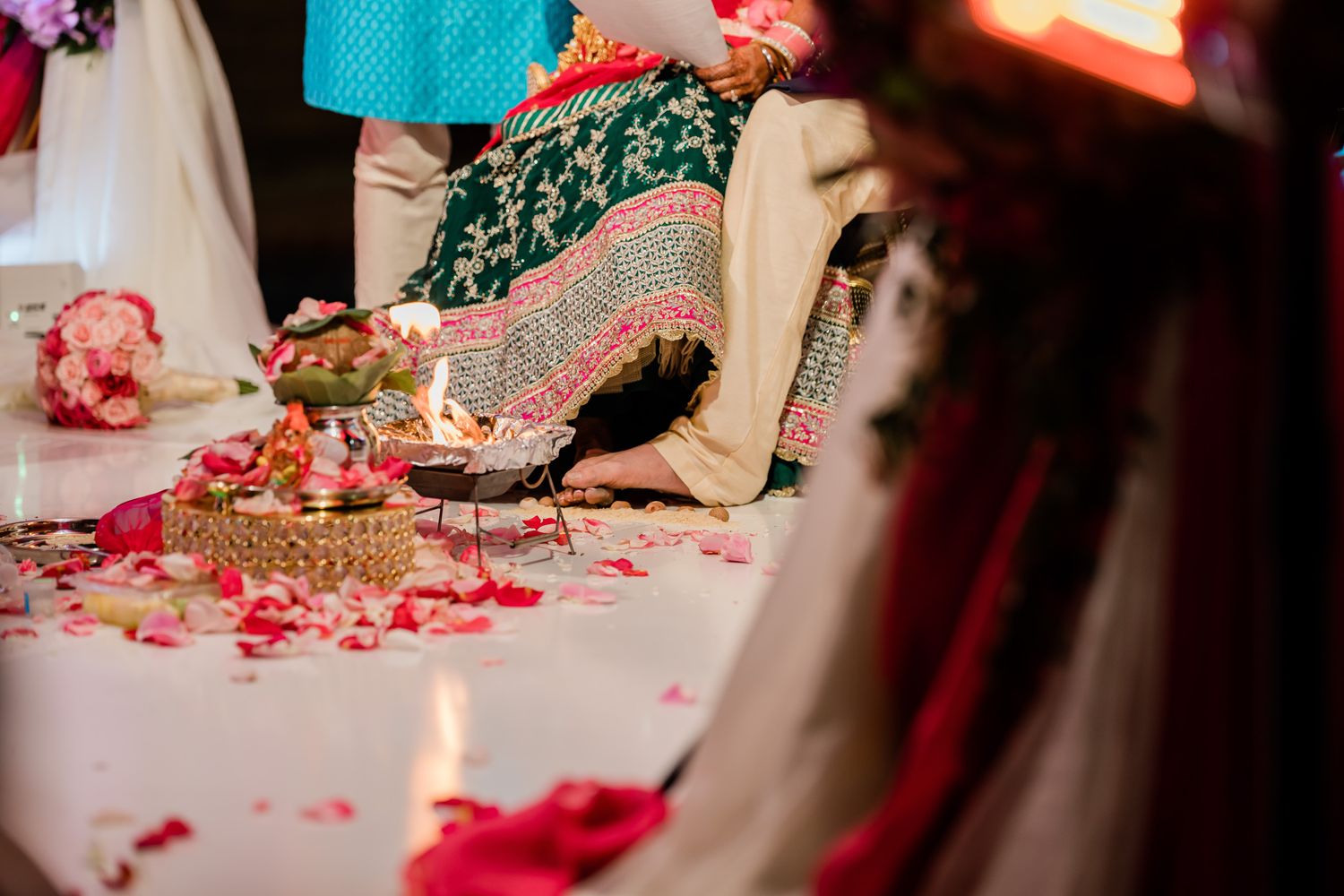 Close-up of traditional Indian wedding ceremony with rose petals and decorative elements on display.