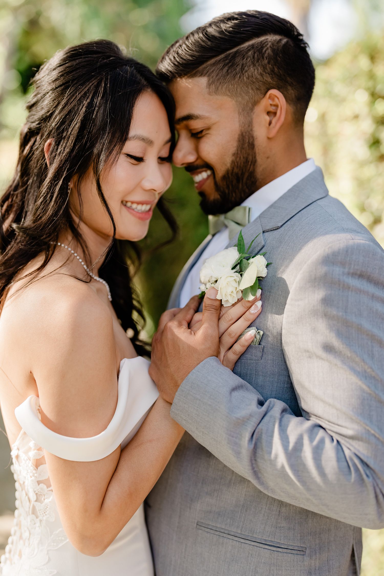 Wedding couple embracing in a romantic garden setting with soft natural lighting.