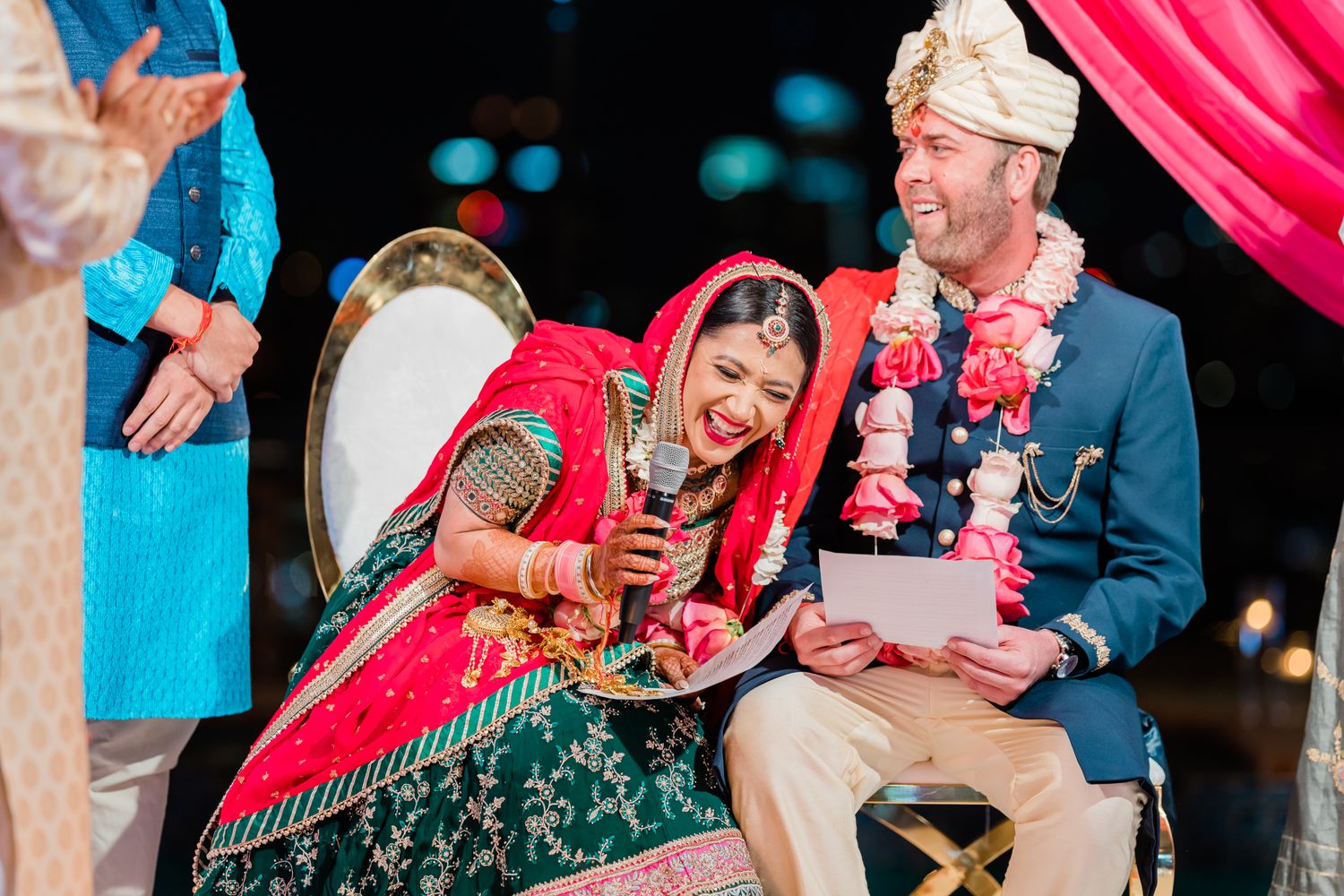 Wedding guests share joyful moments during a vibrant celebration with pink and blue decor.