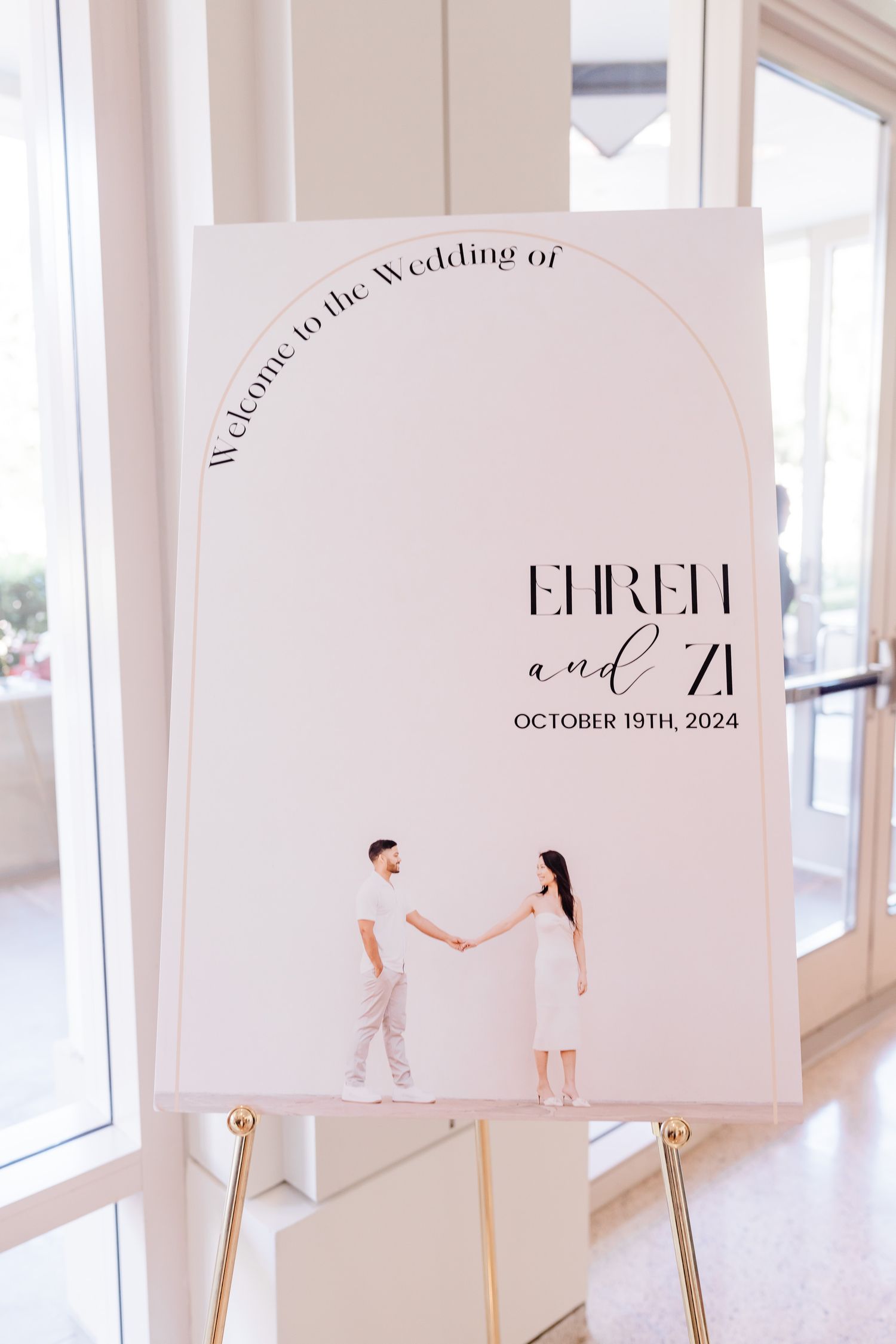 Modern minimalist wedding invitation designs displayed on white stands in a bright interior.