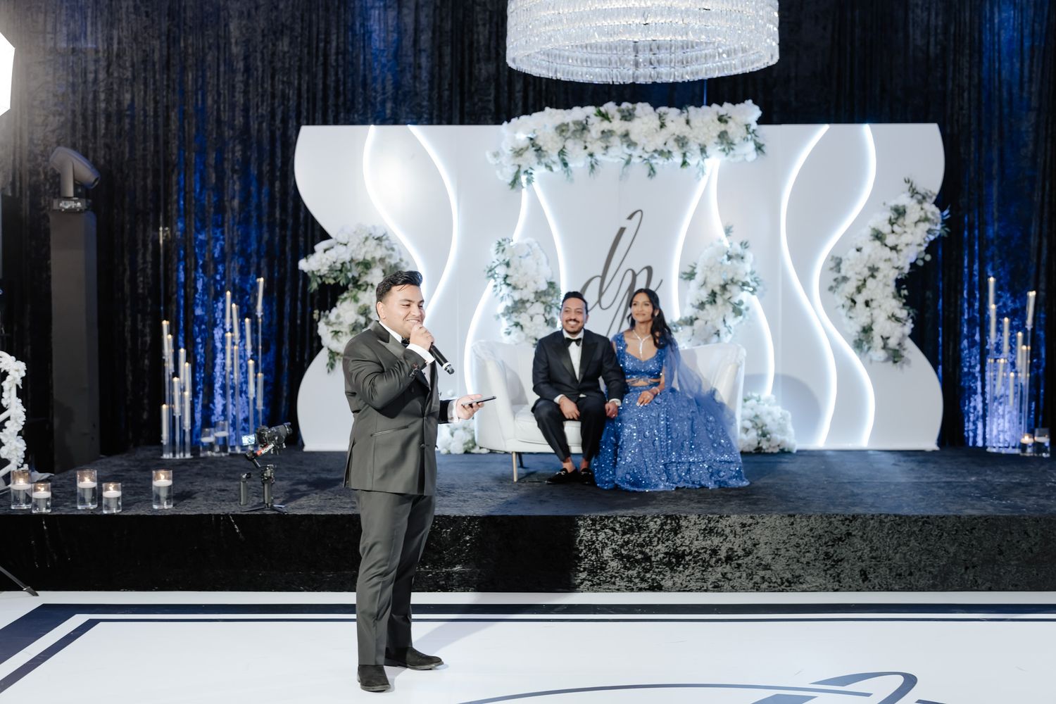 Elegant dance performance on a modern stage with white geometric backdrop and blue atmospheric lighting.