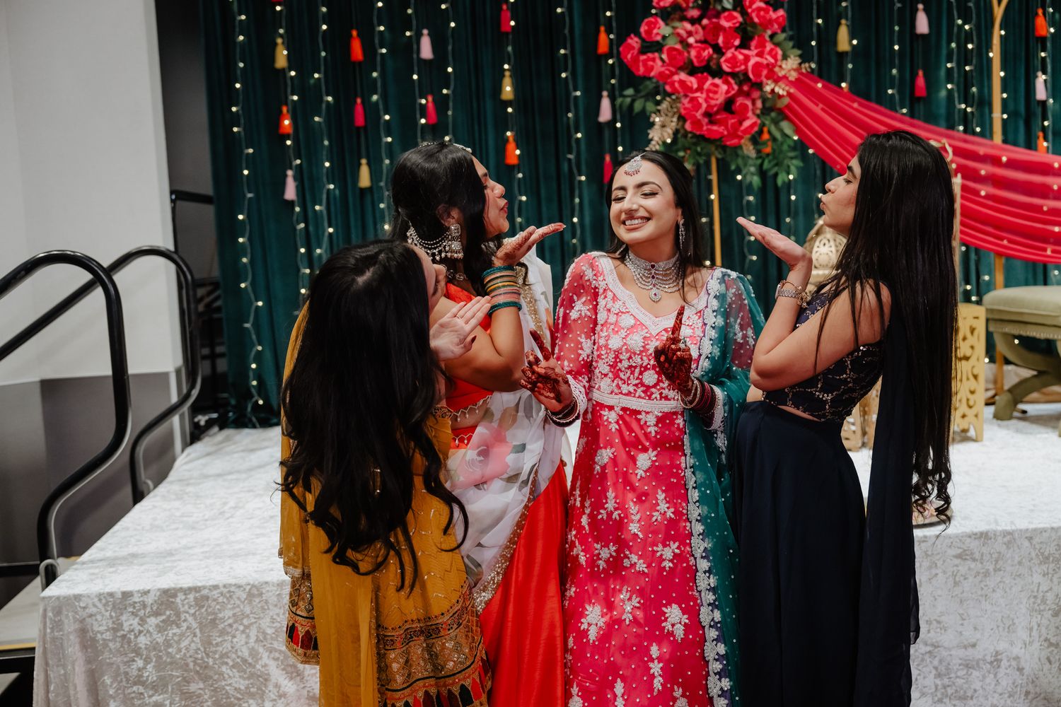 Festive wedding celebration with red and green decor featuring guests enjoying the dance floor.