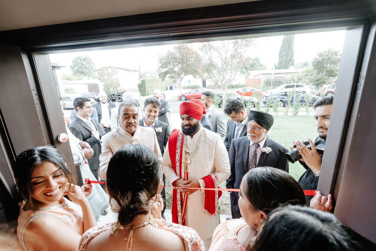 Wedding guests gathering indoors at a reception venue with decorative elements.