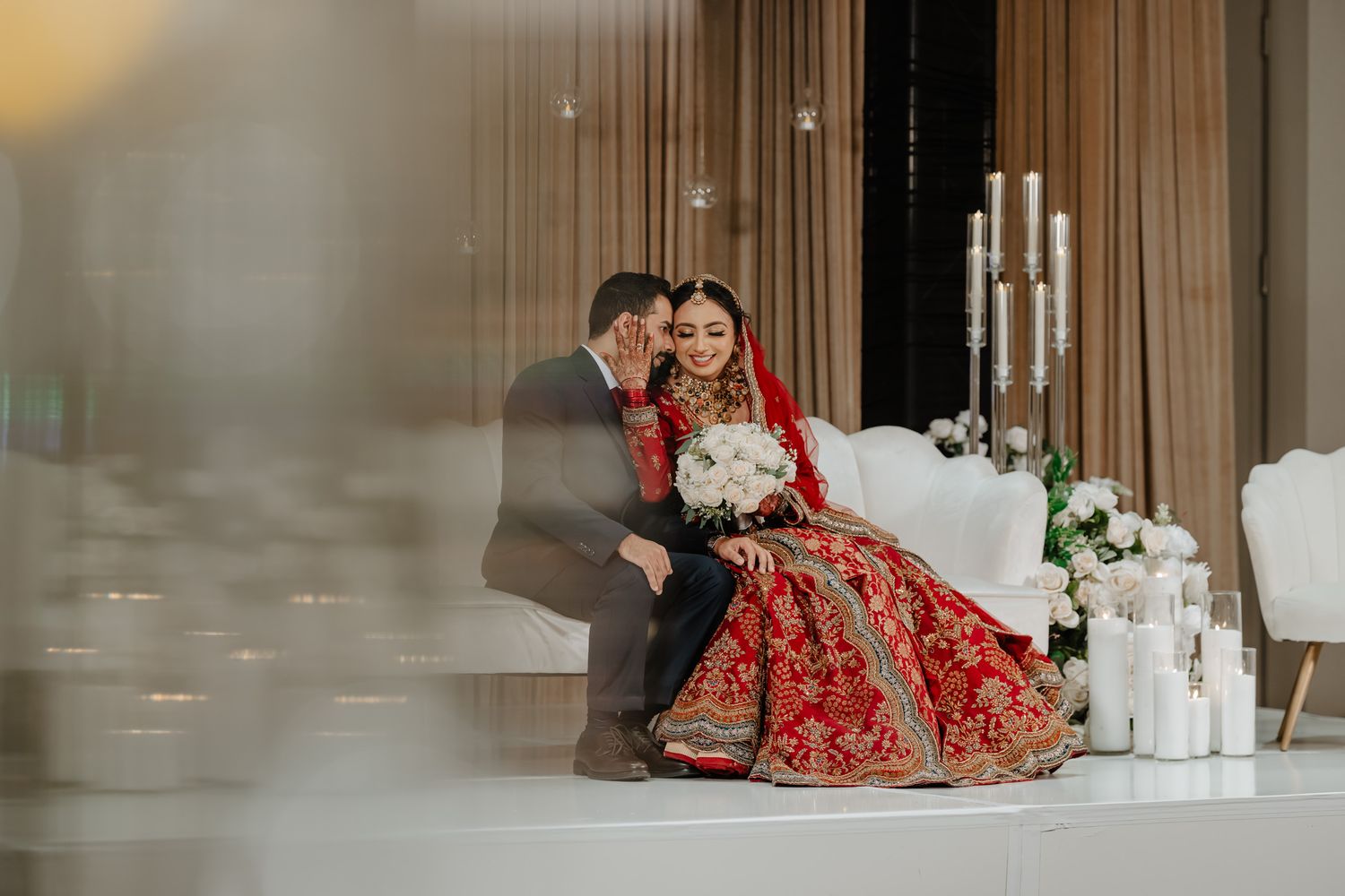 Elegant wedding couple shares intimate moments in a modern indoor venue.