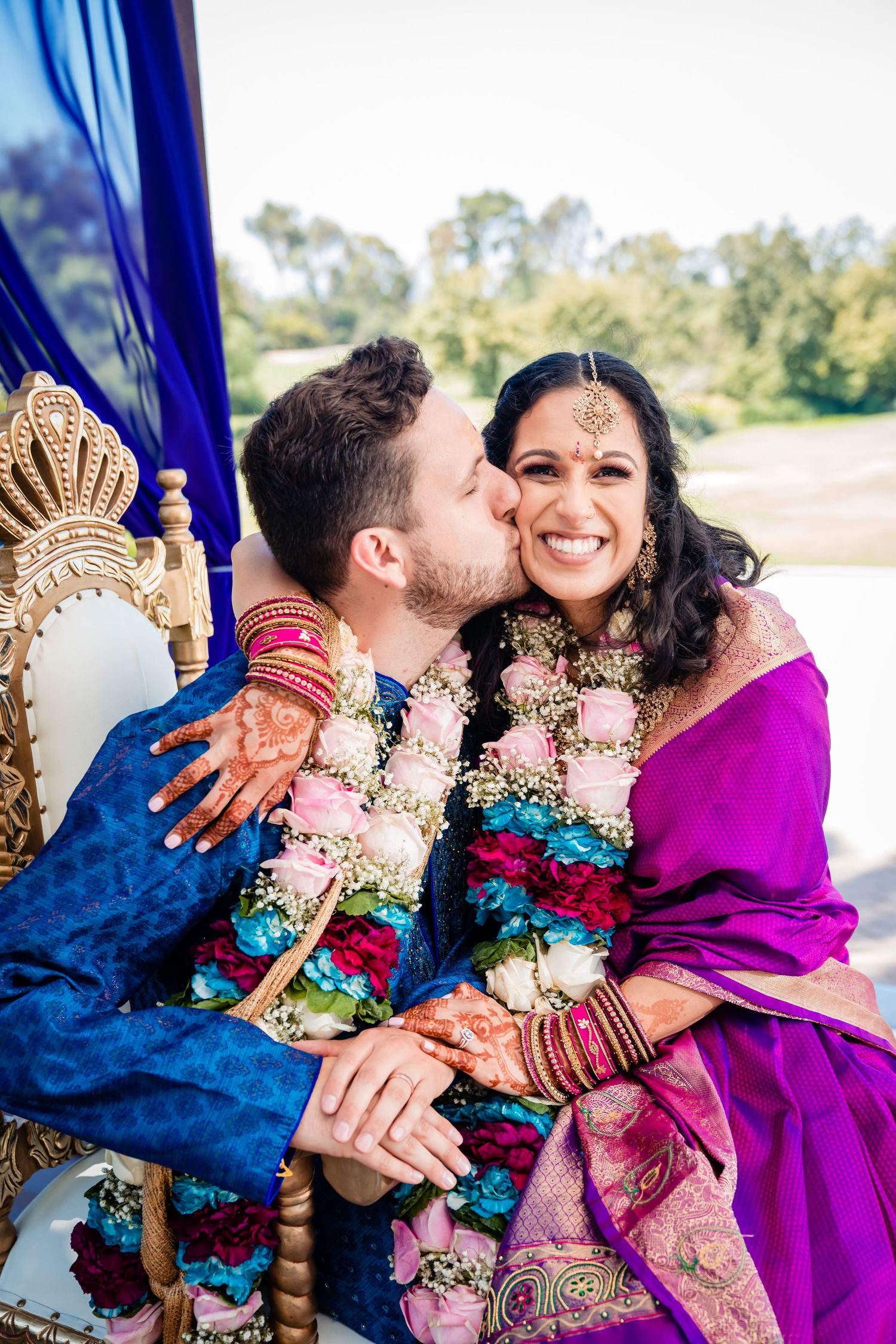 A couple in traditional Indian wedding attire share joyful moments in a series of candid outdoor photographs.