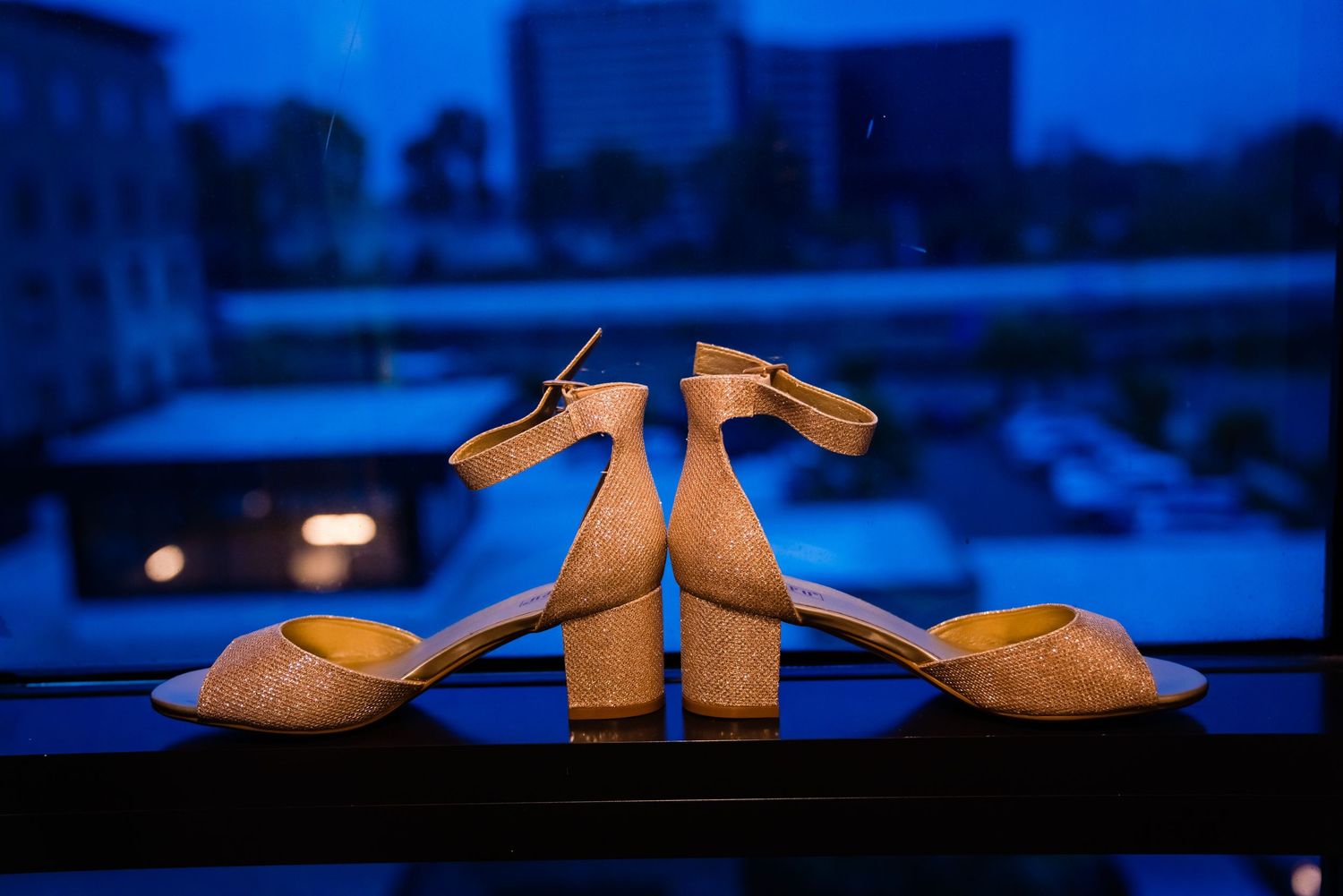 Tan leather mule sandals with block heels displayed in a row against a dark blue background.