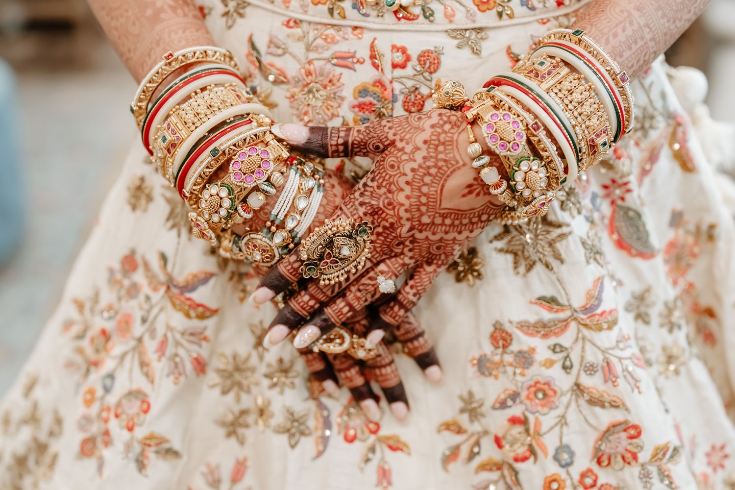 Delicate floral embroidery detail on wedding attire in soft peach tones.