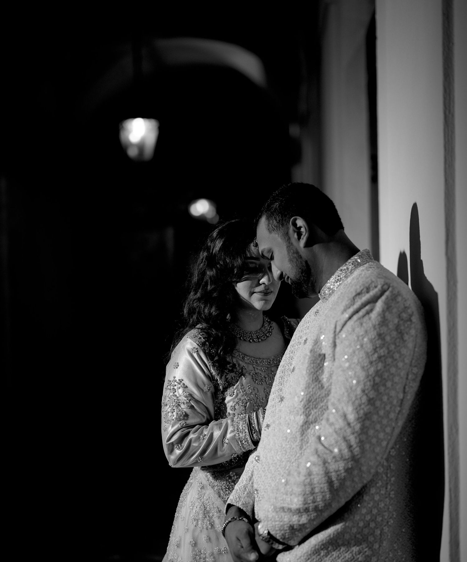 A romantic black and white photo series showing a couple embracing and kissing in an intimate moment.