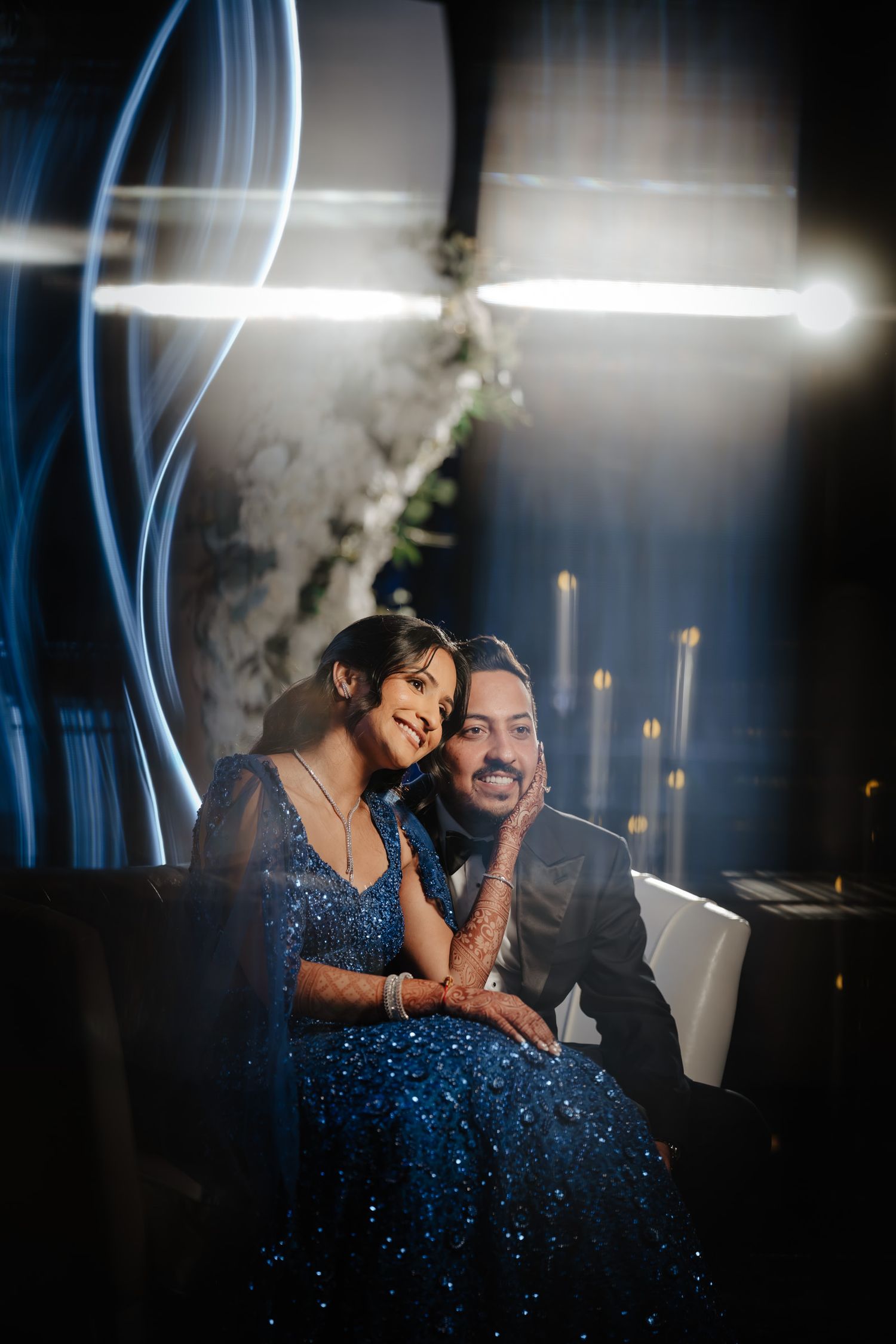 Romantic couple in formal attire sharing an intimate moment by a piano with dramatic lighting and candles.