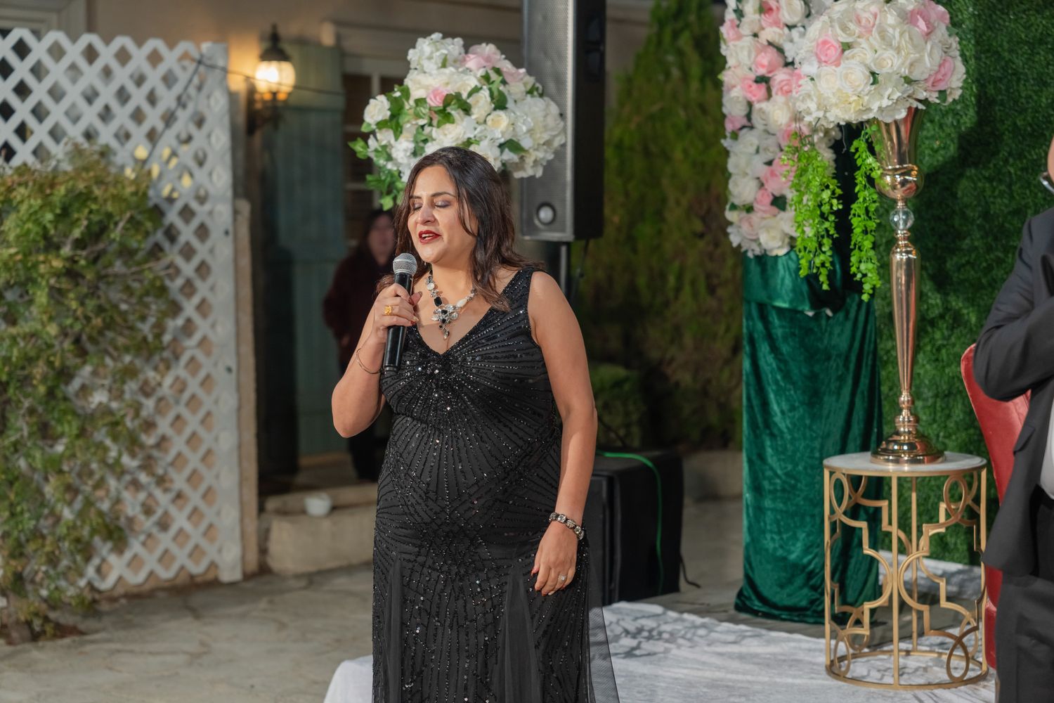Wedding celebration guests enjoying a festive moment at an outdoor reception with elegant decor and lighting.