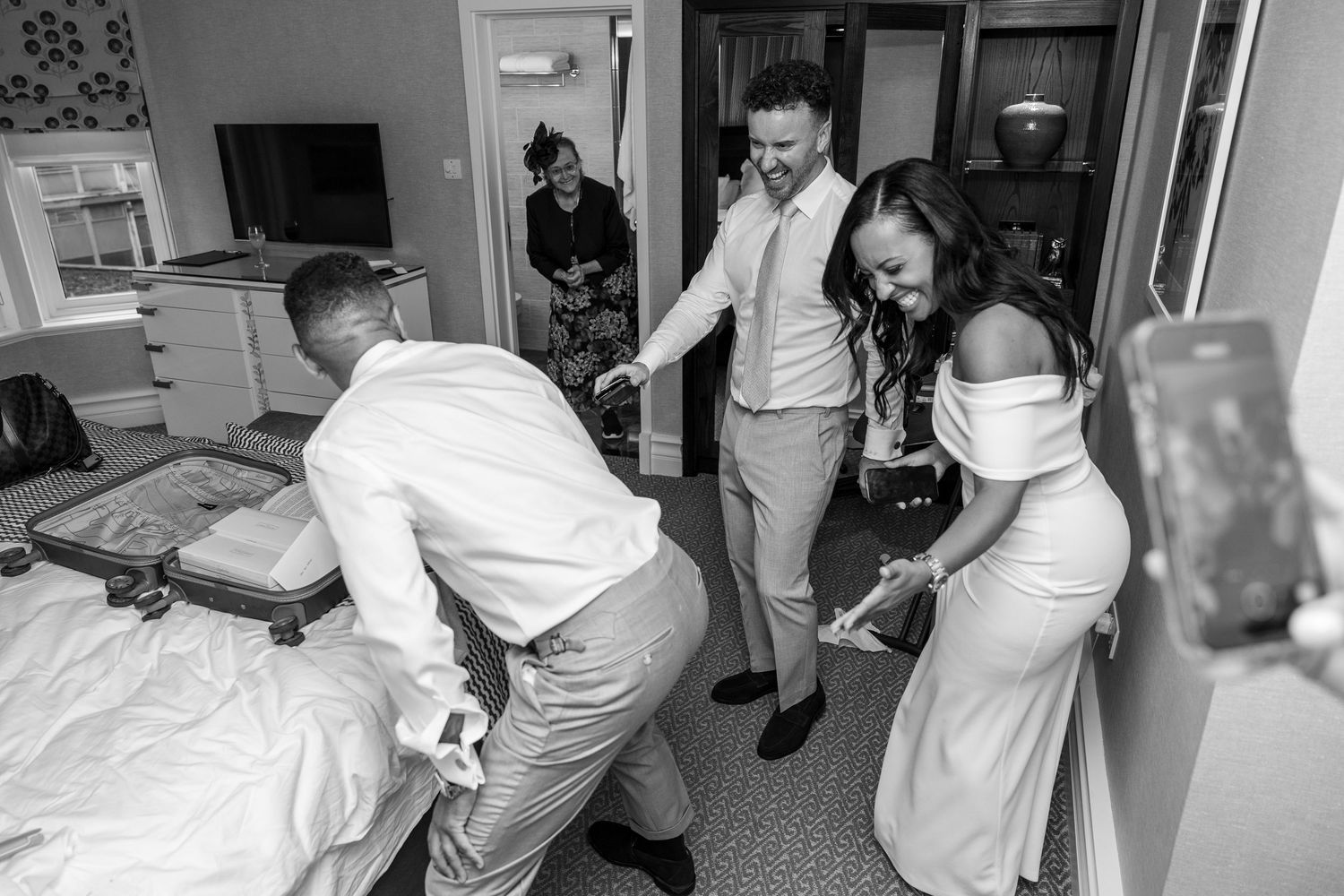 Groom laughing with friends during wedding preparations.