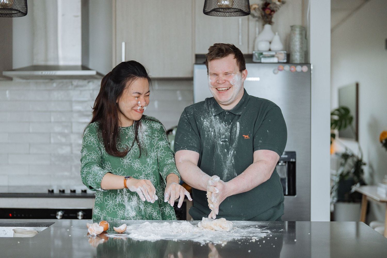 A couple makes a mess while baking together in their kitchen.