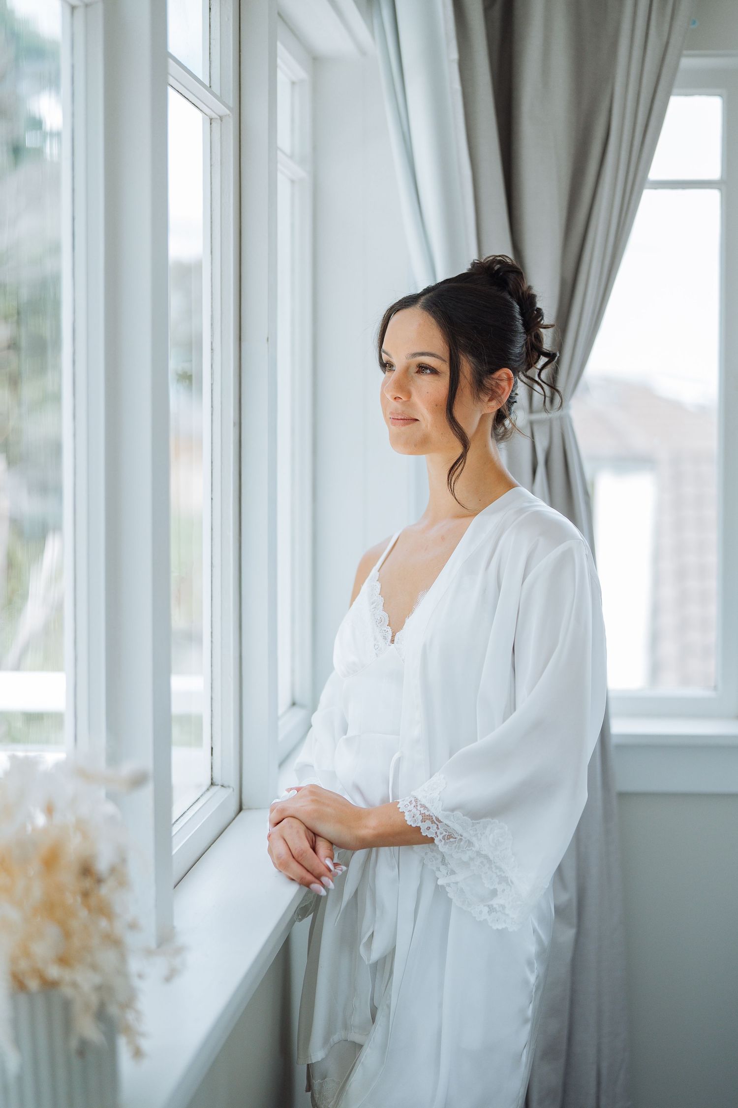 Bright sunlit room with white curtains and windows creating a serene morning atmosphere.