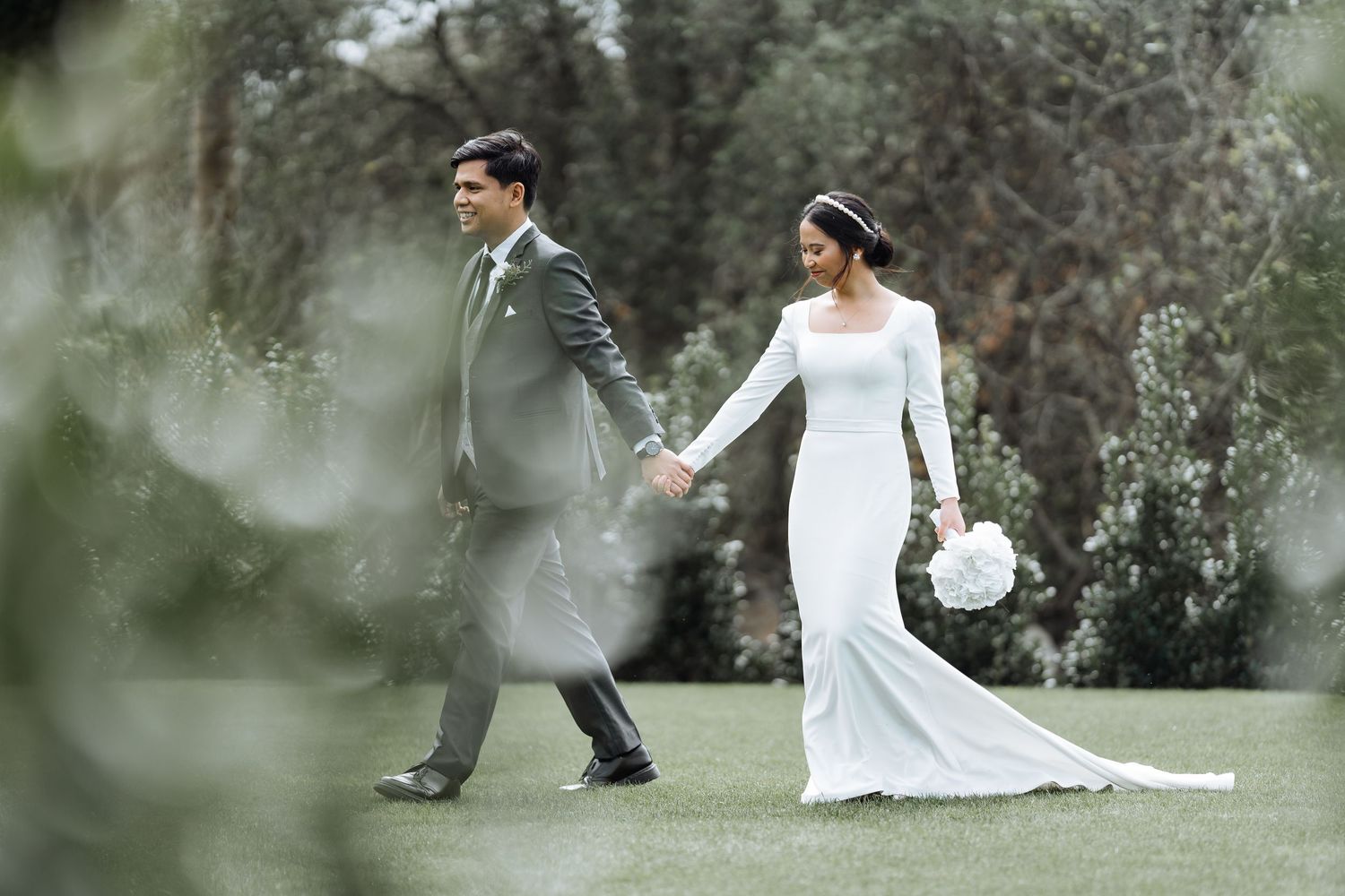 Romantic wedding portraits captured through soft focus foliage.