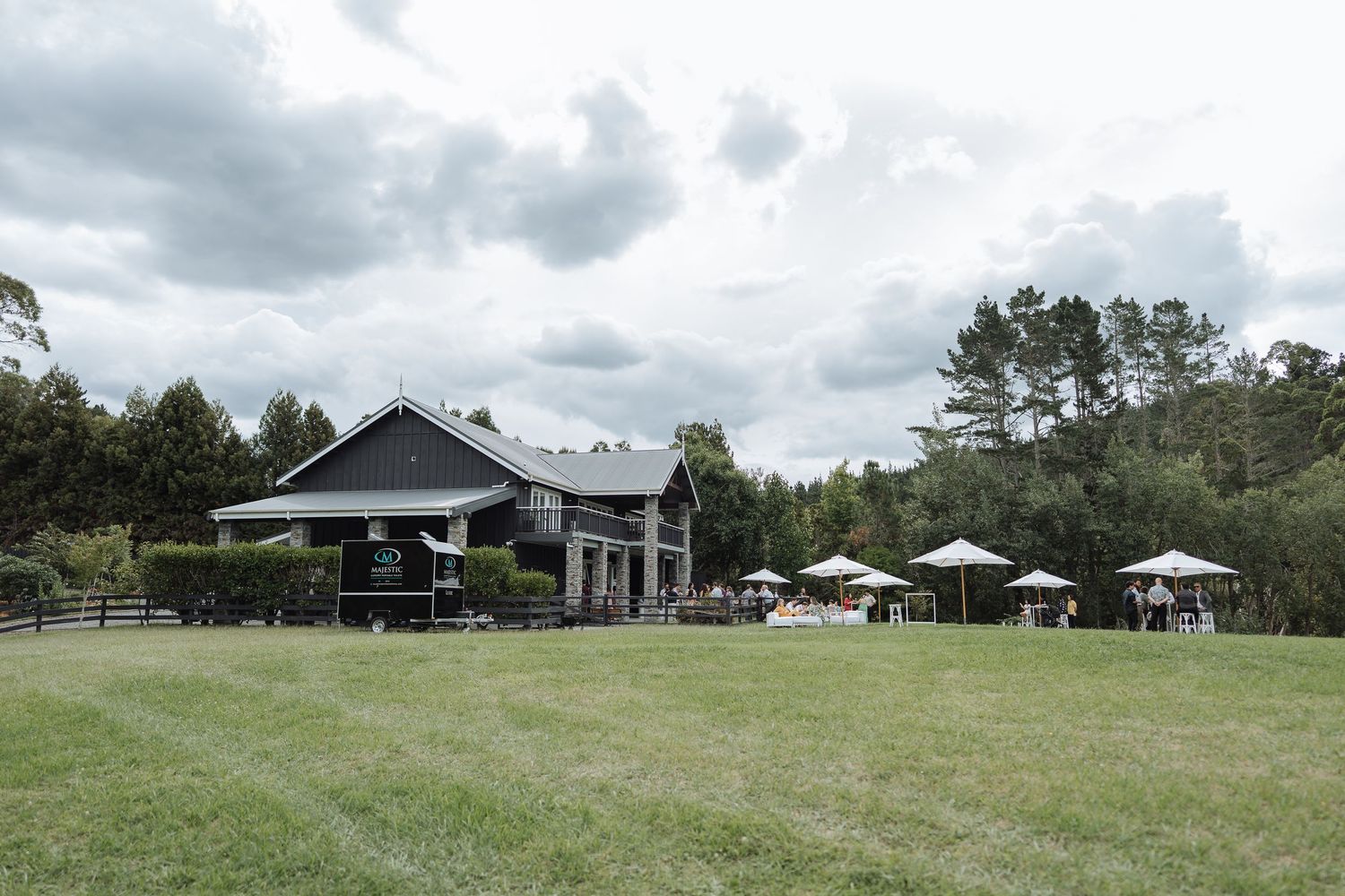 Panoramic view of outdoor wedding venue with tents and natural landscape.