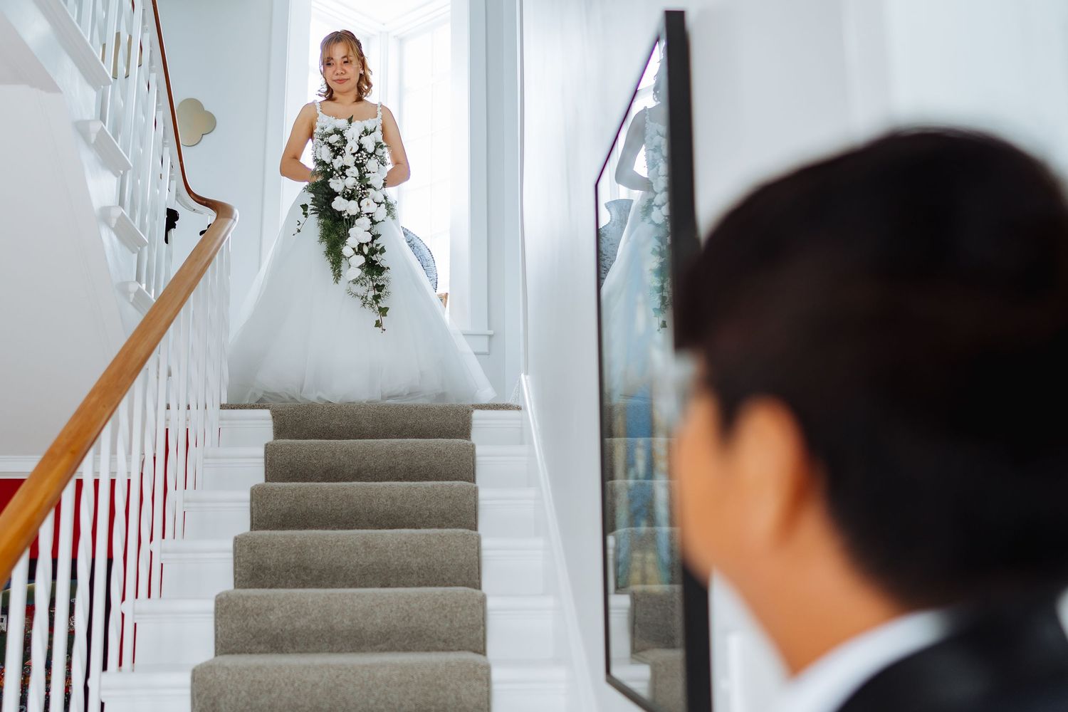 White staircase with wooden handrail in an elegant interior setting.