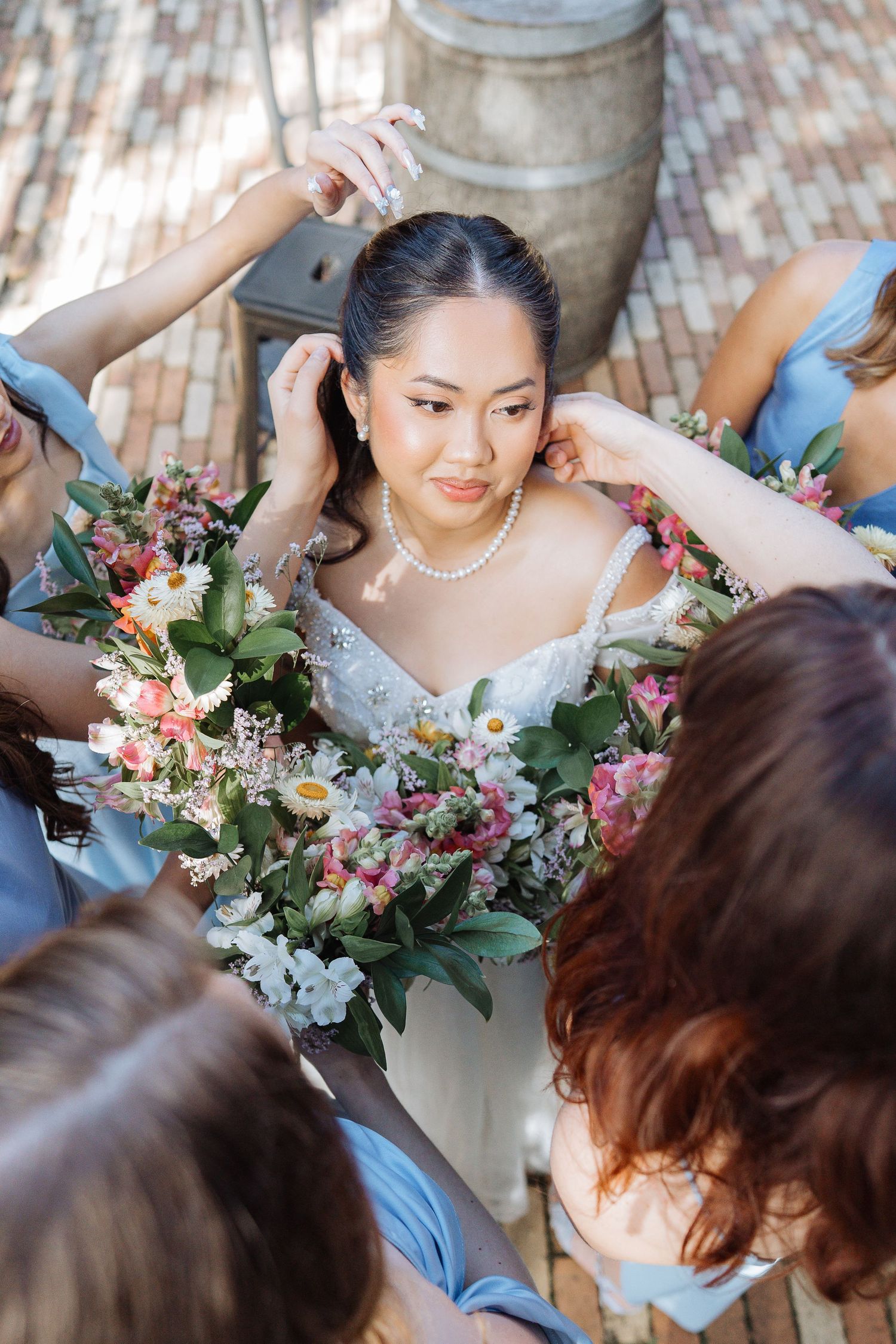 Wedding party members help arrange floral decorations and accessories before the ceremony.