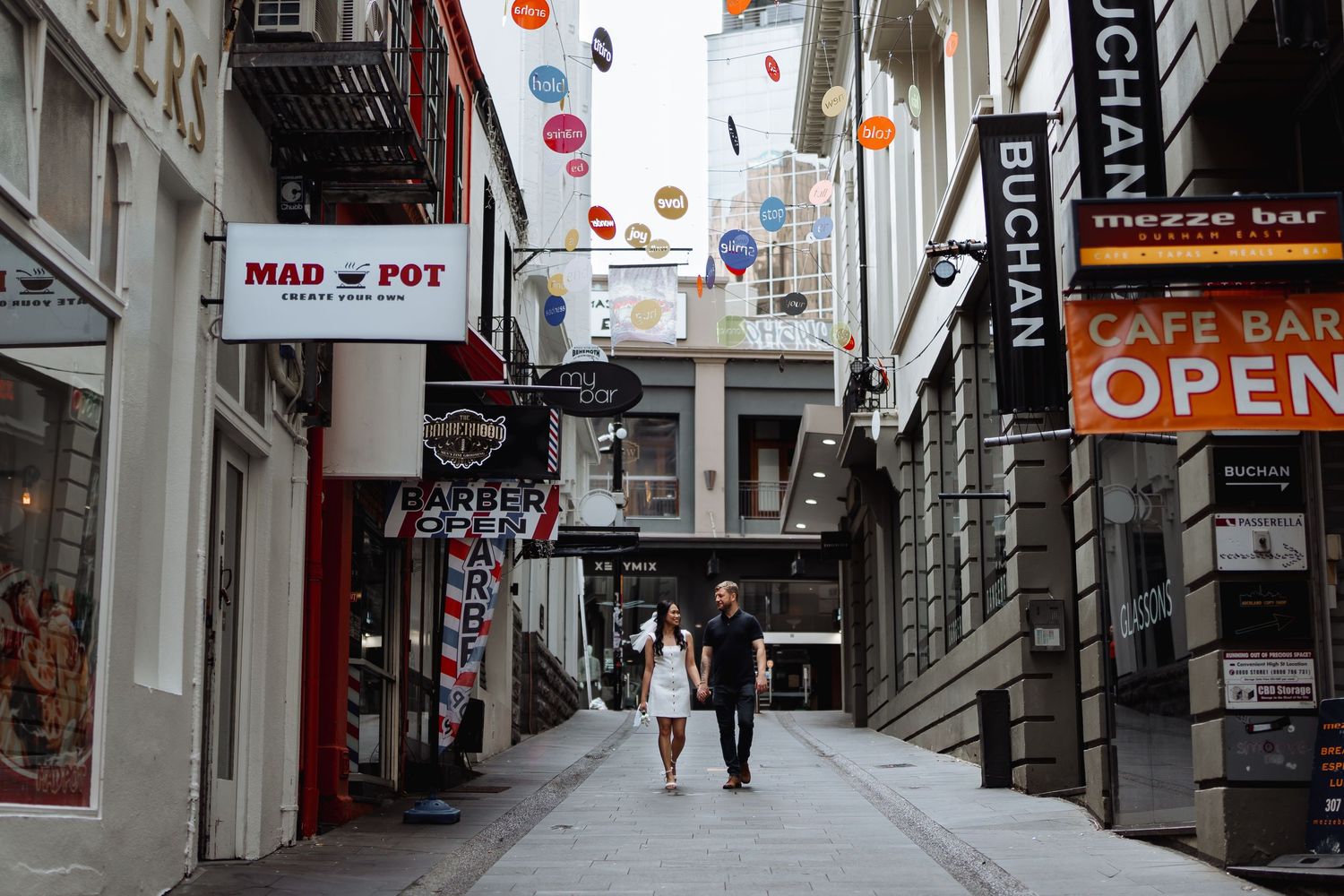 Empty urban alleyway with storefronts and business signs.