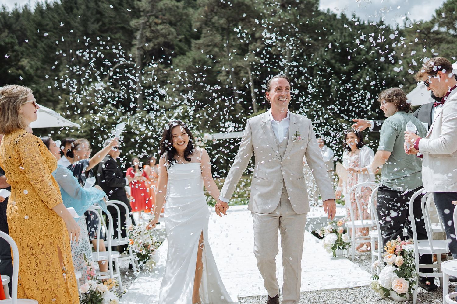 Wedding celebration sequence showing guests throwing confetti during an outdoor ceremony.