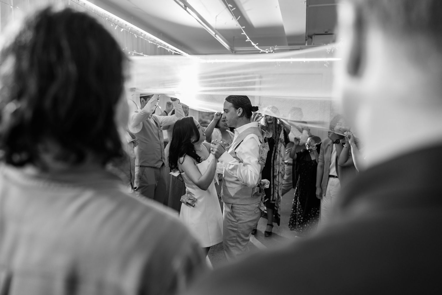 Black and white photo of a lively dance floor celebration with sparklers creating a festive atmosphere.