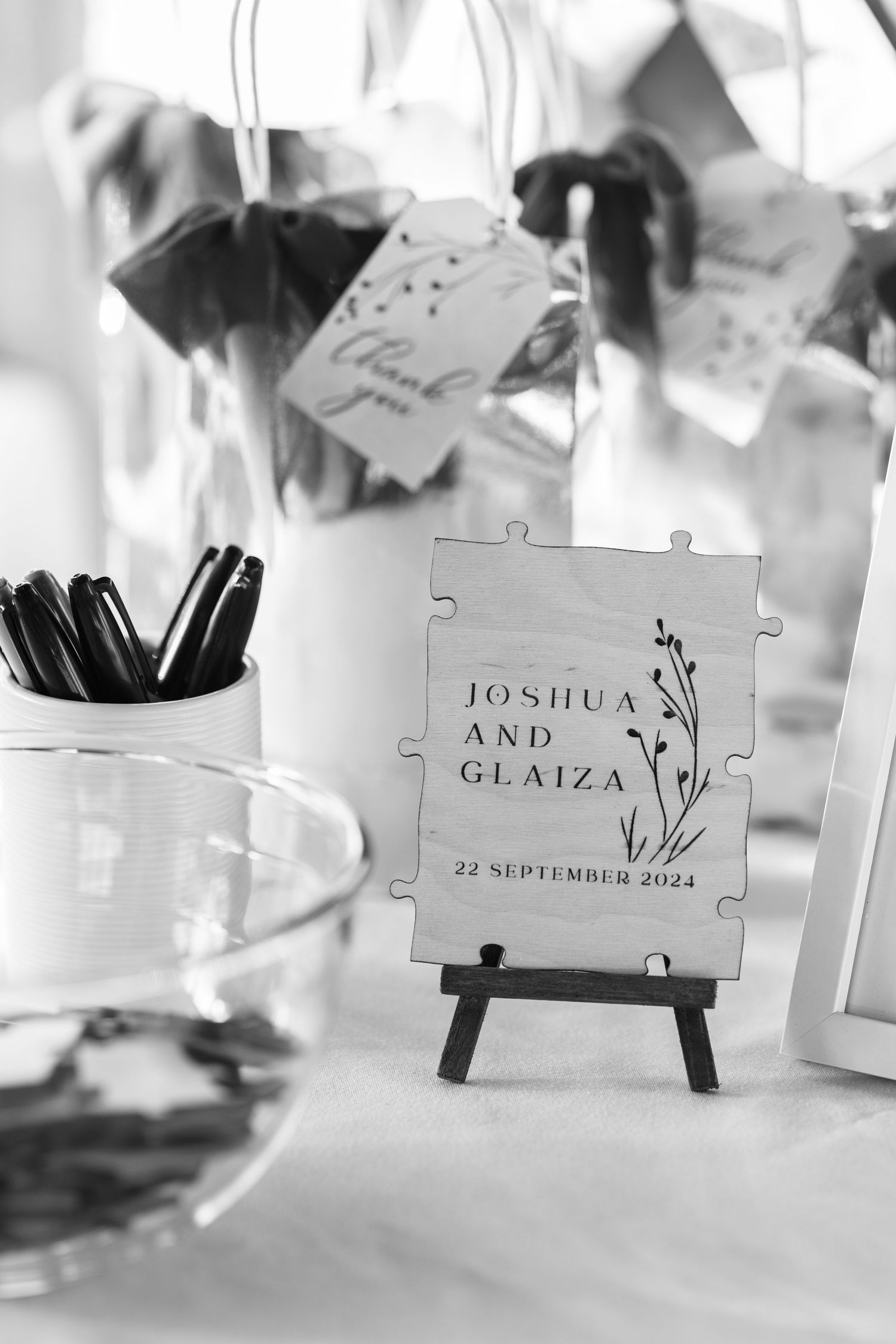 Wedding name cards displayed on puzzle piece holders with elegant calligraphy for Joshua and Glaiza's September celebration.