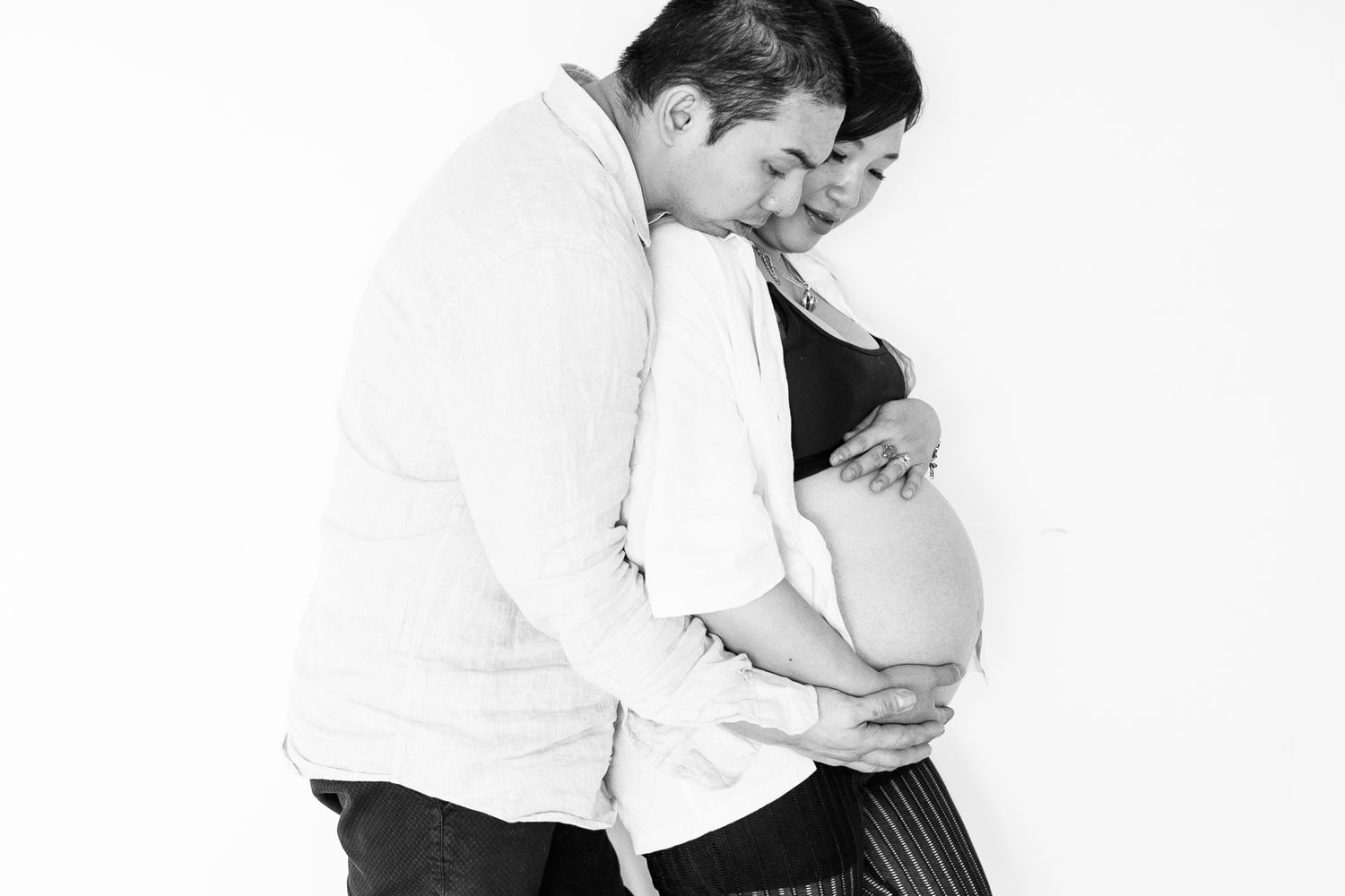 Minimalist studio portraits capturing intimate moments between two figures in monochrome.