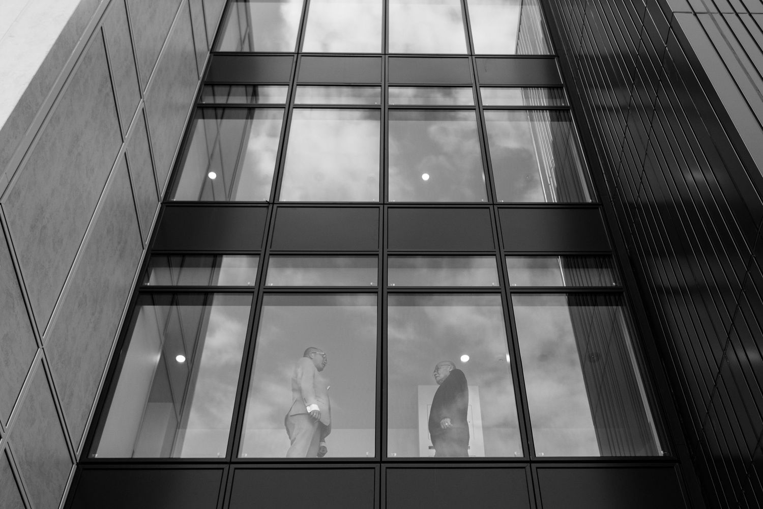 Architectural detail of modern building windows creating geometric patterns in black and white.