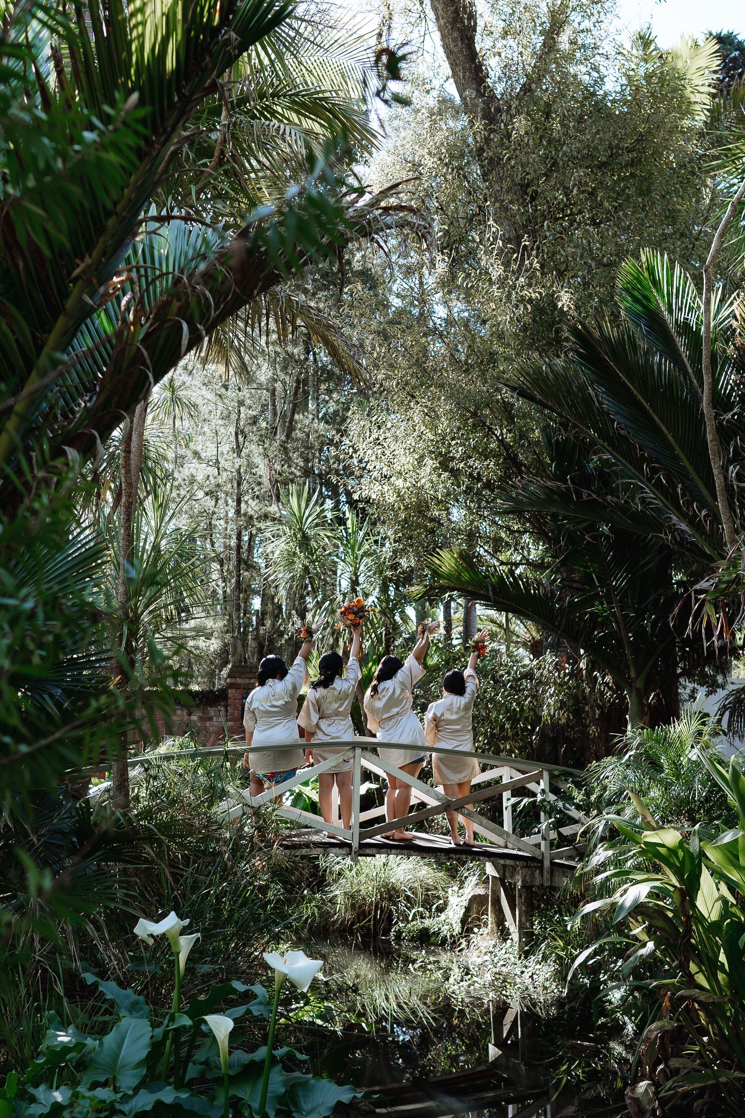 Group poses on a wooden walkway surrounded by lush tropical foliage.