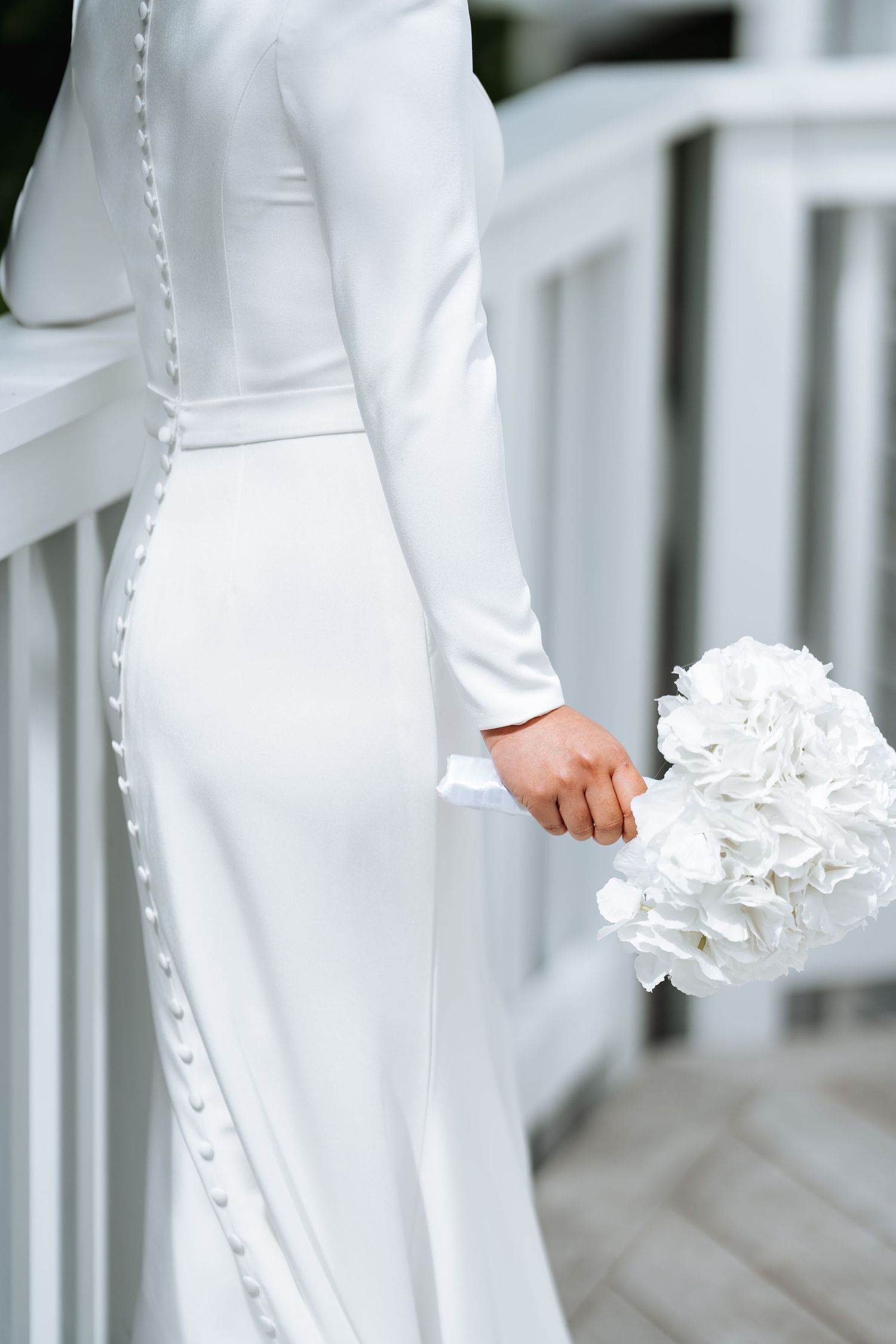 Close-up of elegant white wedding dress details with delicate ruffles.