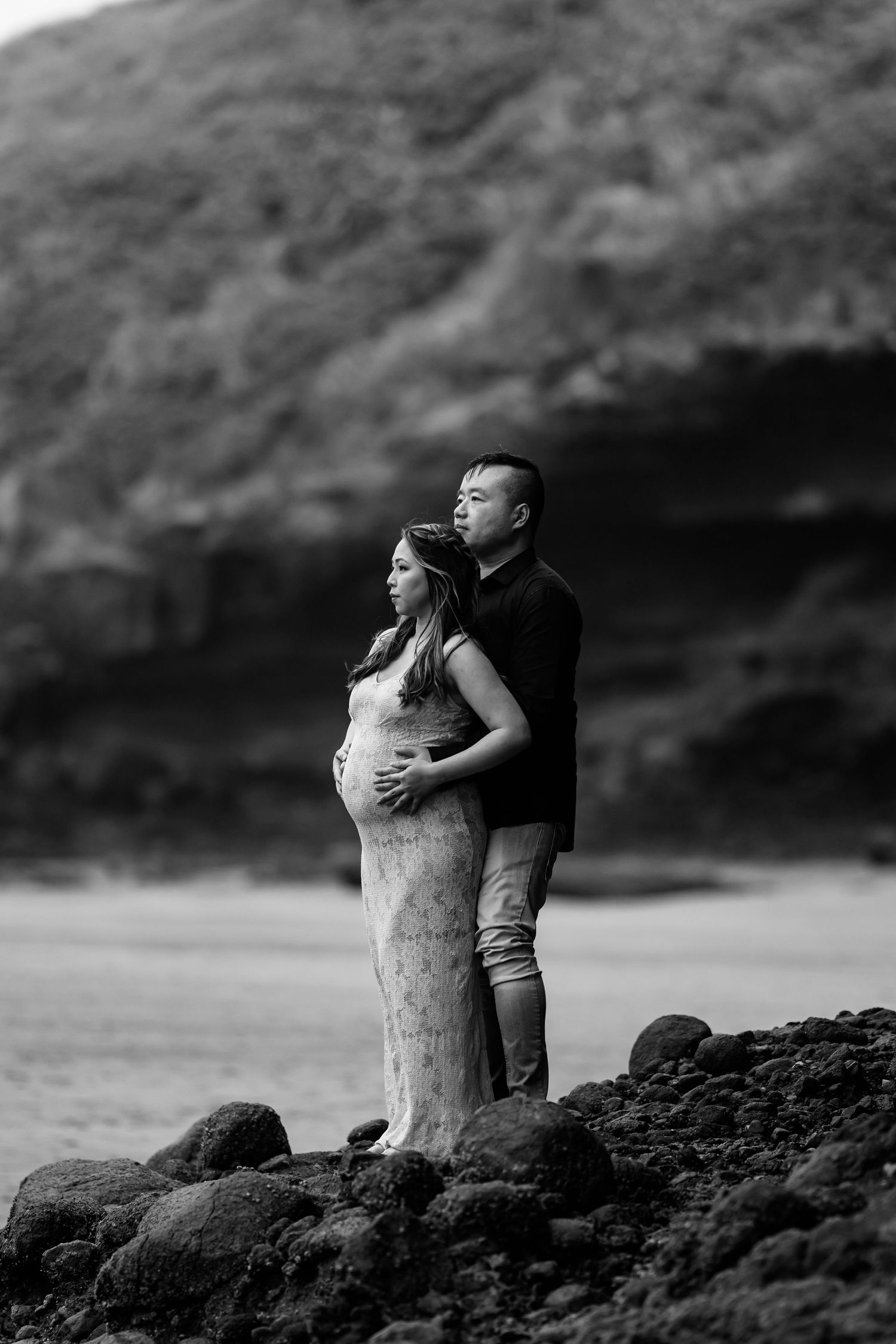 Black and white photo sequence showing a romantic moment on rocky beach terrain.