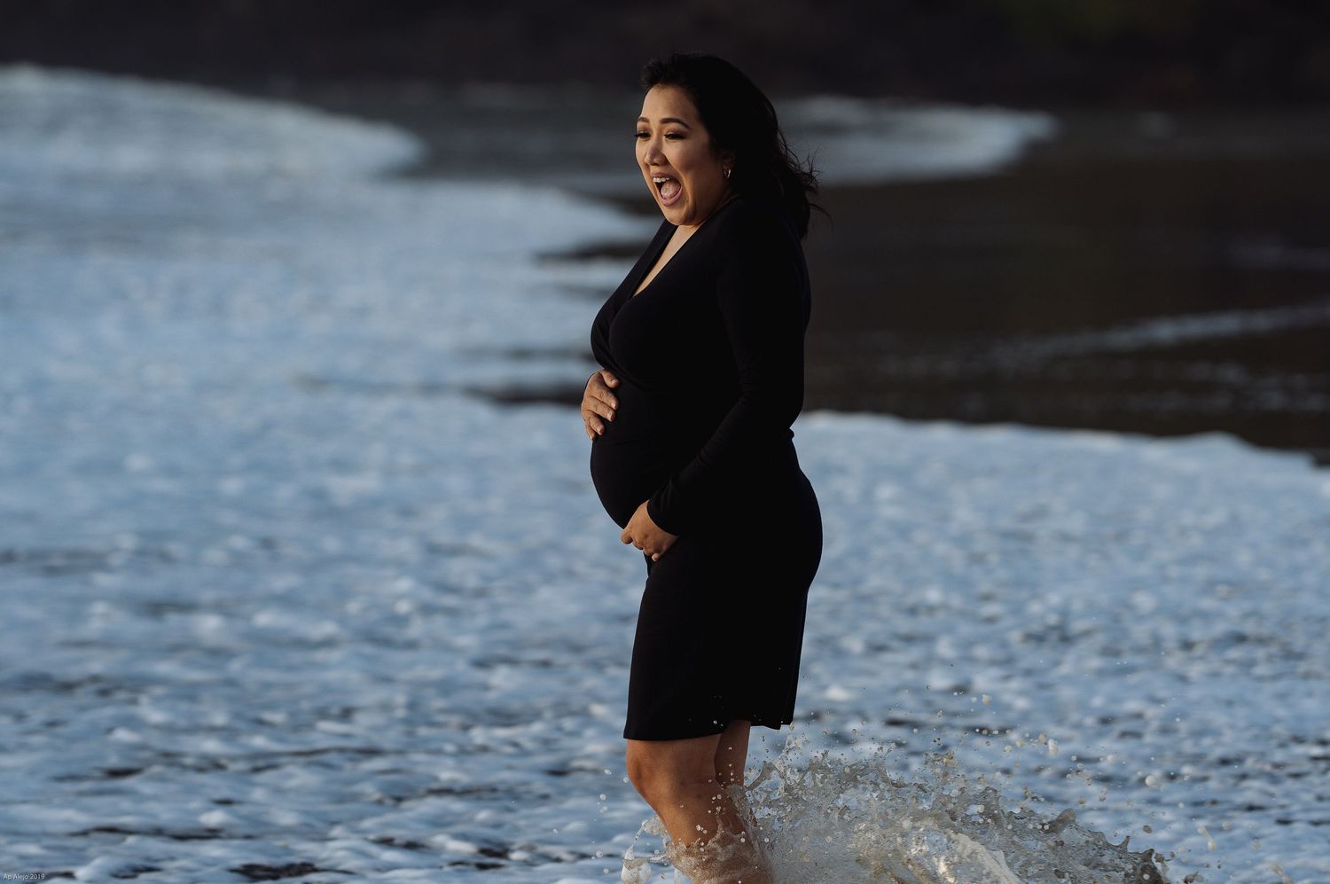 Beach portrait with waves and dark shadows creating moody atmosphere.