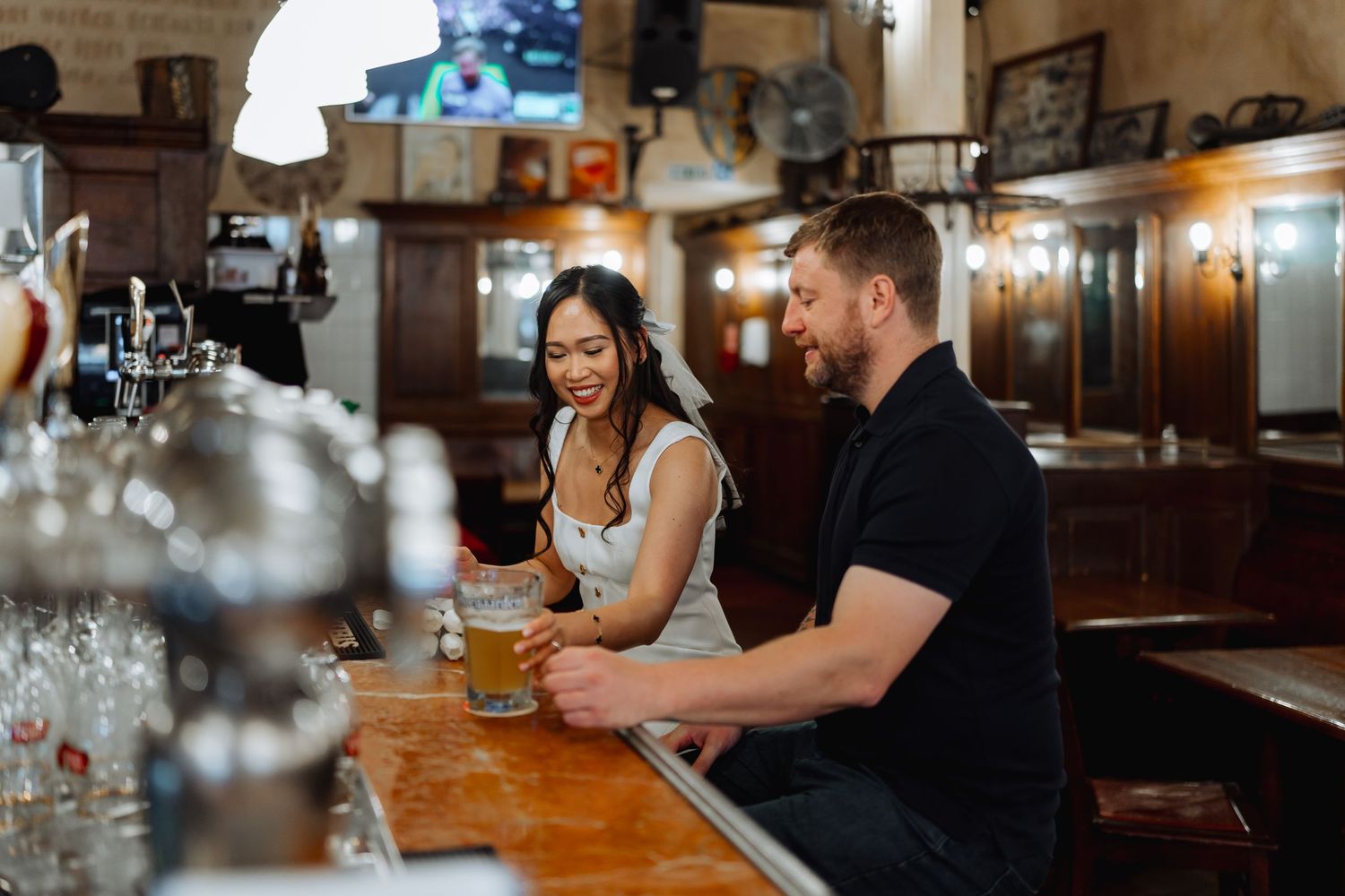 Couple enjoying drinks together at a rustic wooden bar counter.