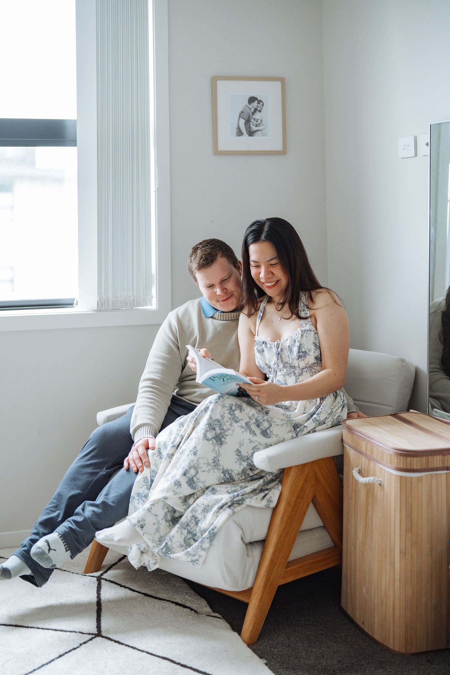 Couple sharing intimate moments on a wooden couch in a bright modern room.