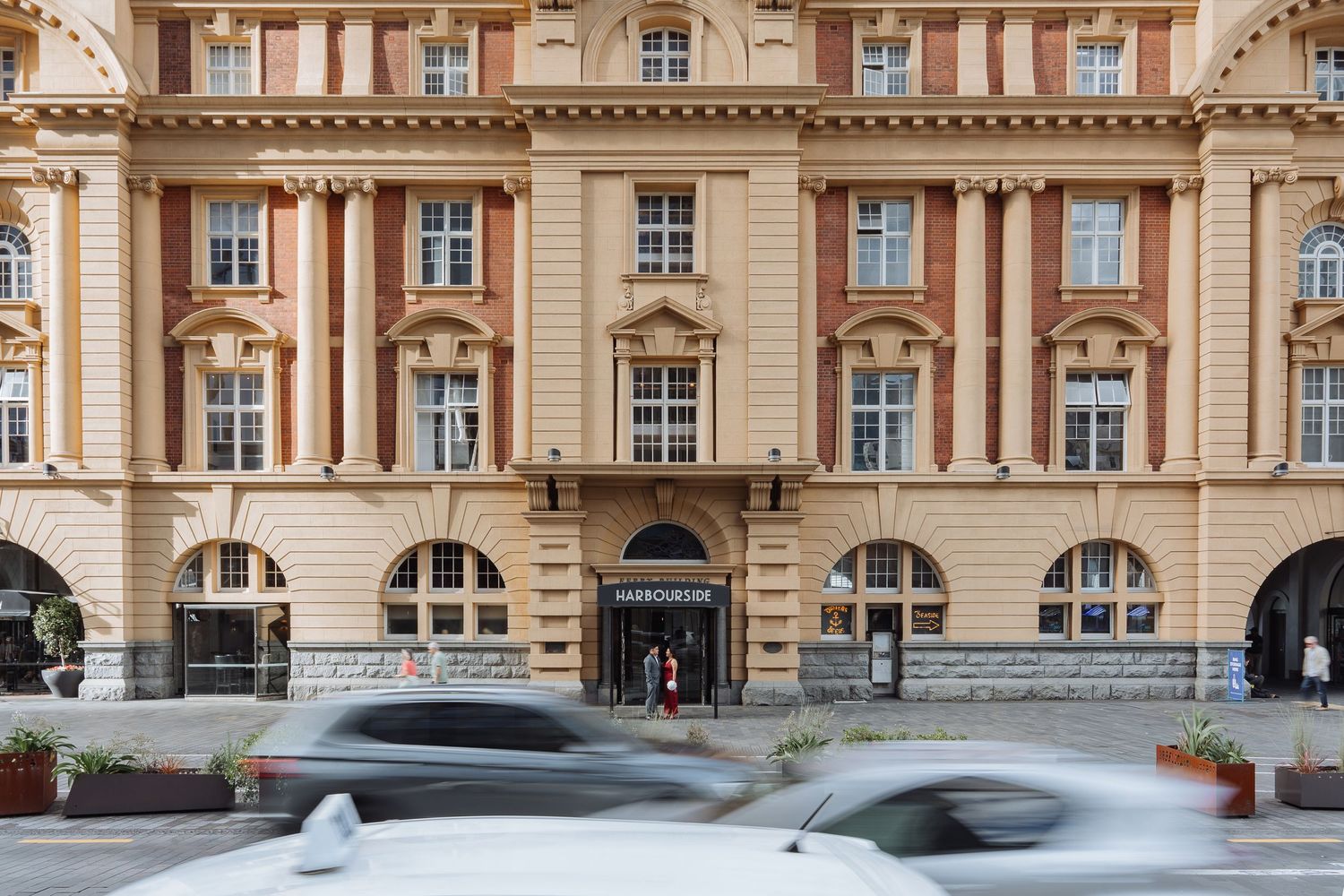 Classical architecture building facade with beige stone and arched windows.