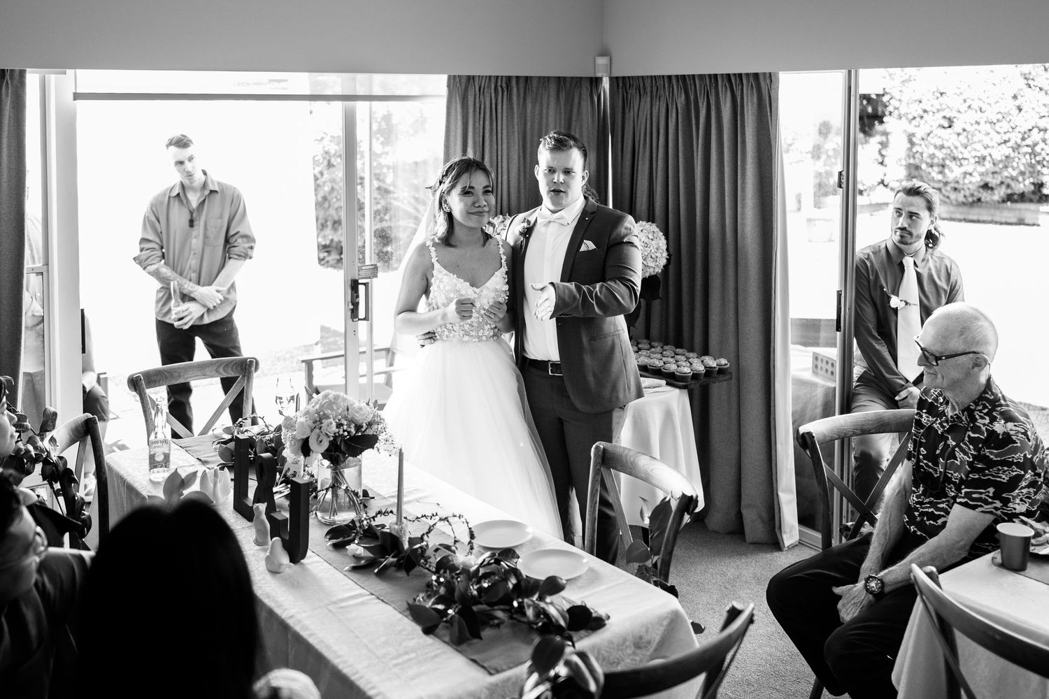 Wedding preparations in a bright indoor room with multiple people getting ready.