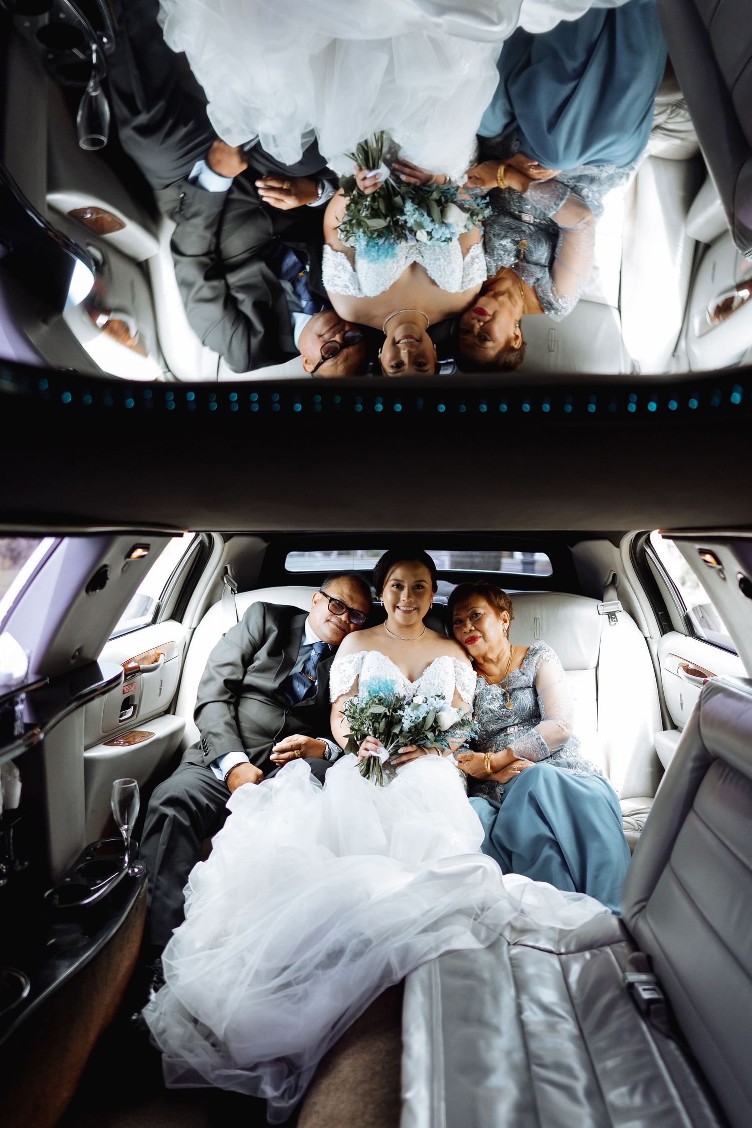 Wedding party seated in limousine with flowing white dress filling the frame.