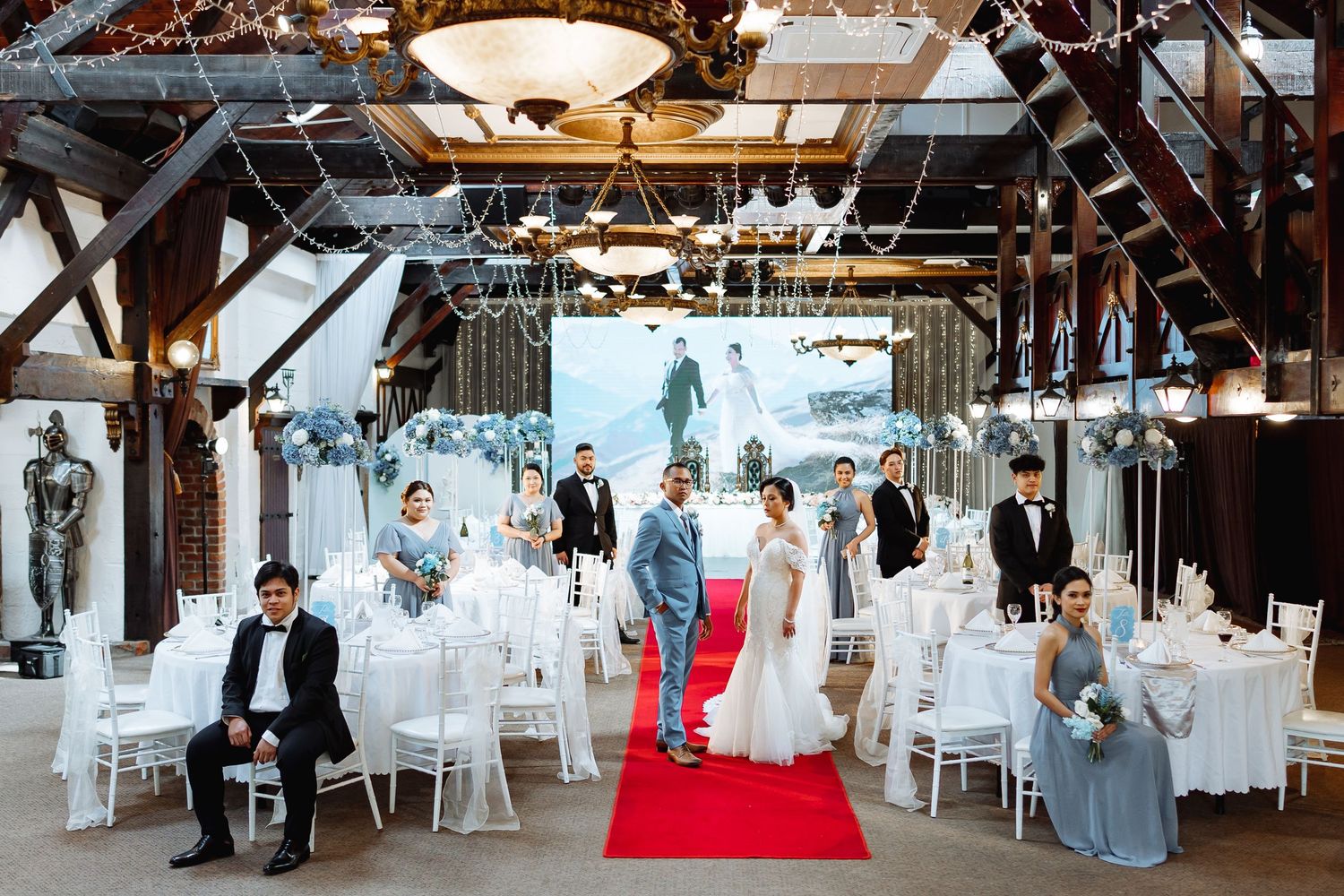 Wedding reception venue decorated with white chairs and elegant lighting.