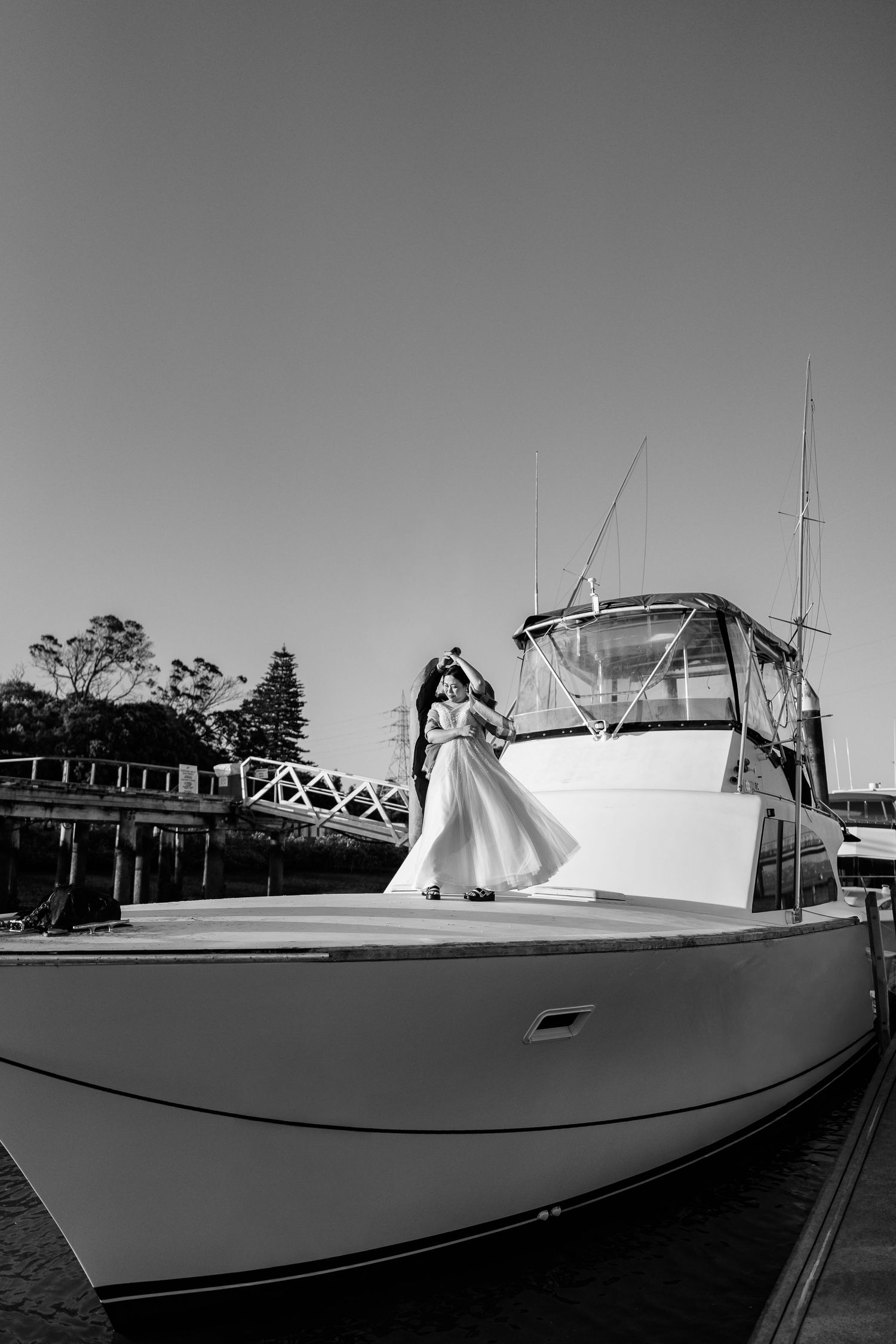 Panoramic view of a white yacht docked at a marina on a clear day.
