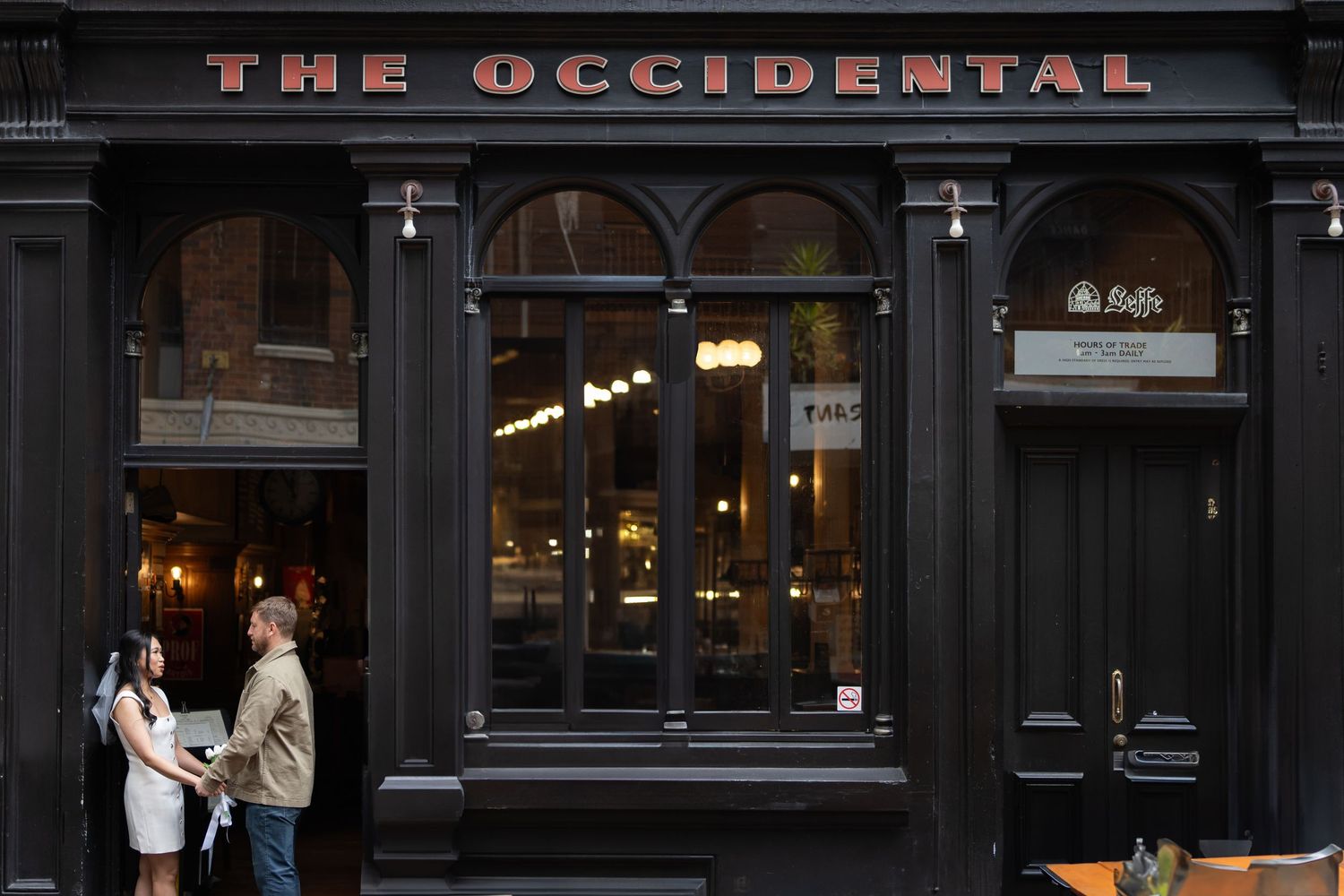 Exterior view of The Occidental storefront with dark facade and illuminated signage.
