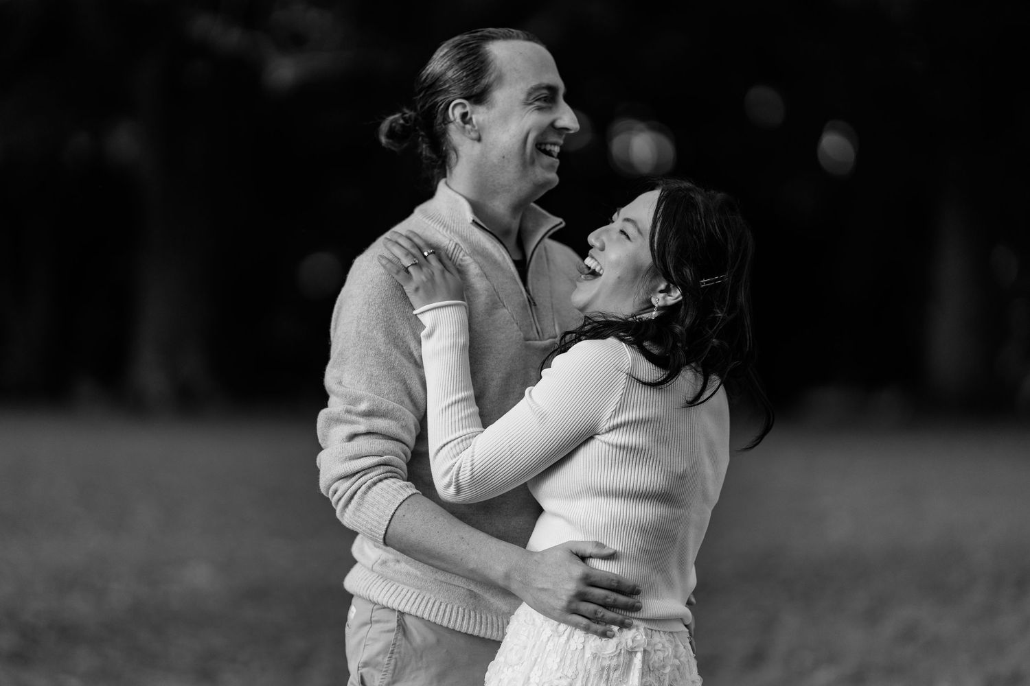 An intimate black and white portrait capturing a joyful moment outdoors.