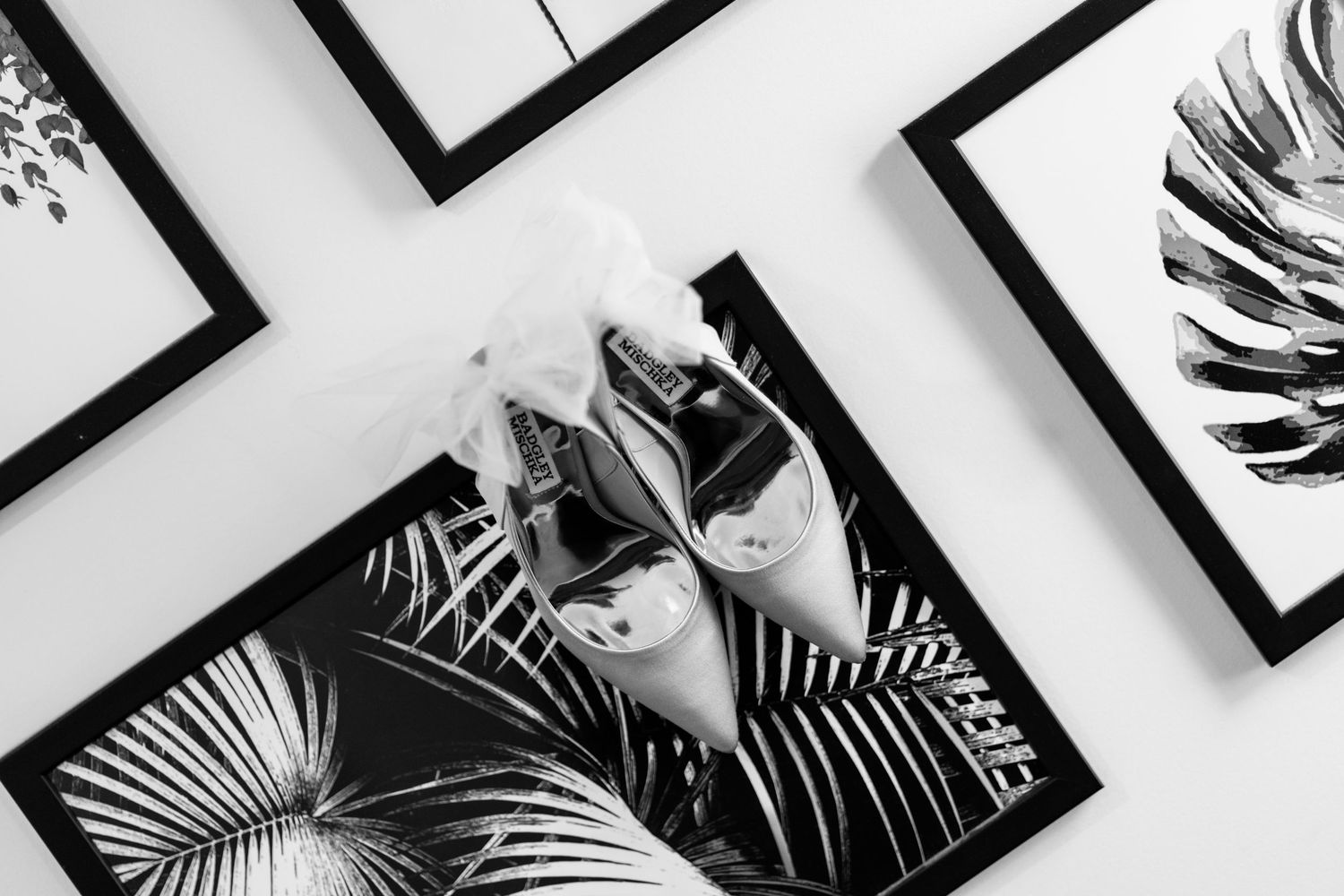Artistic black and white palm leaf prints arranged in a gallery wall display.