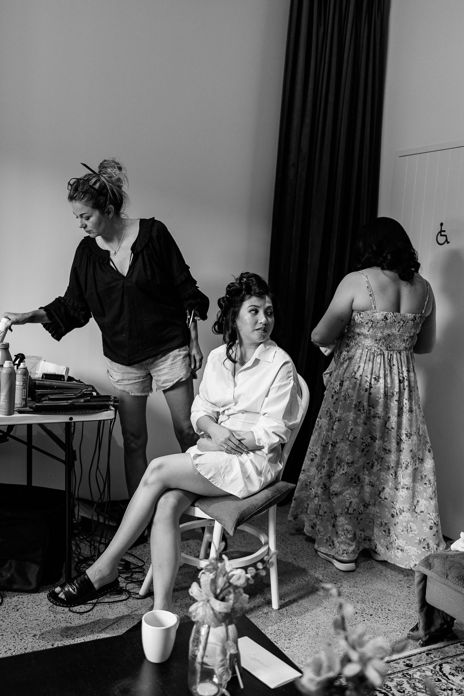 Black and white series showing preparations in a room with floral dress and white clothing.