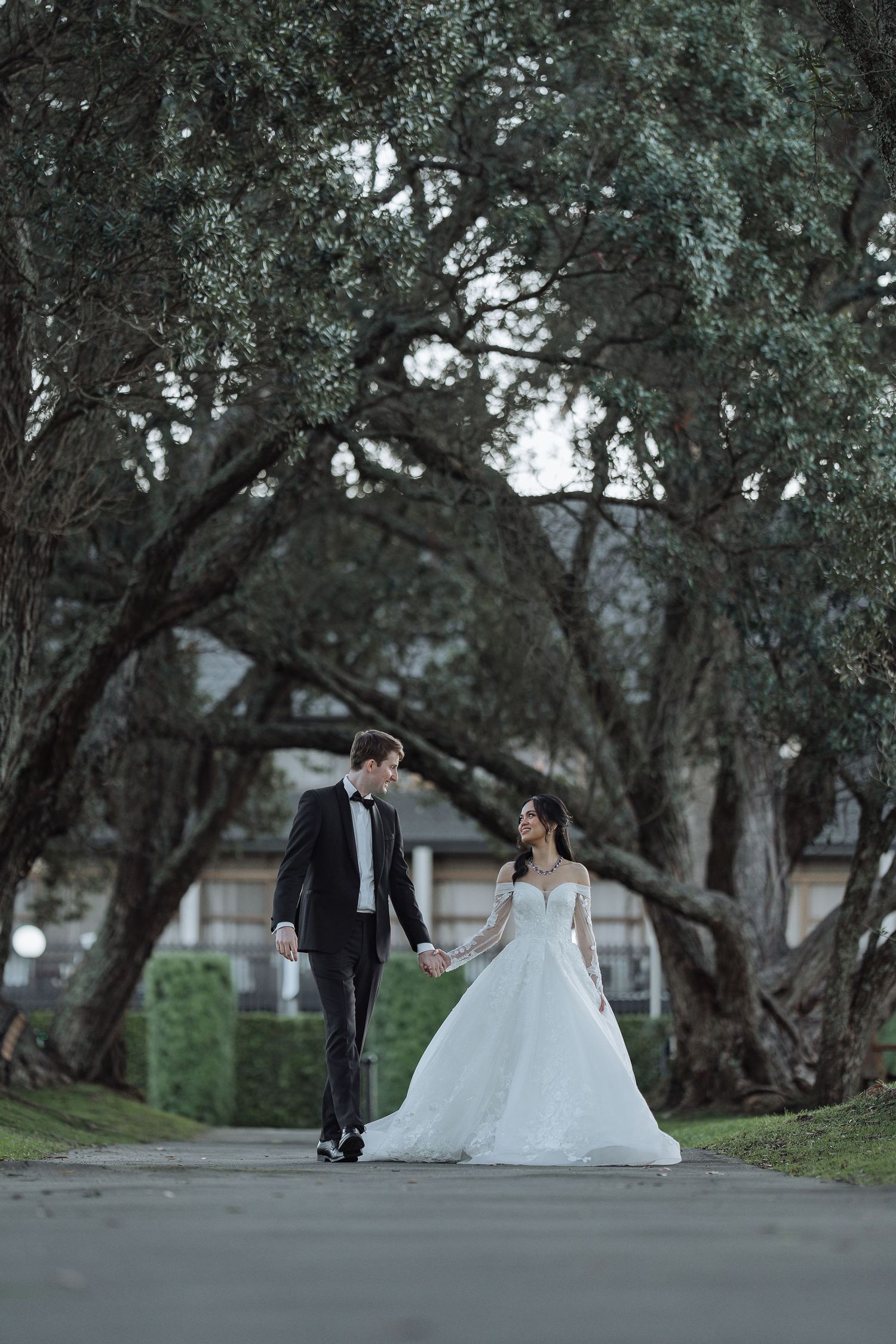 Romantic outdoor wedding photo session in a park with trees creating a natural backdrop.