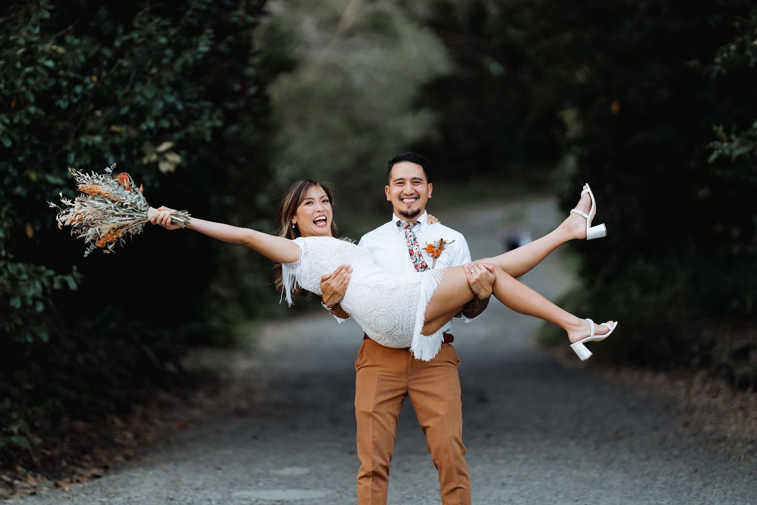 A series of playful outdoor couple poses showing joyful lifts and spins on a forest path.