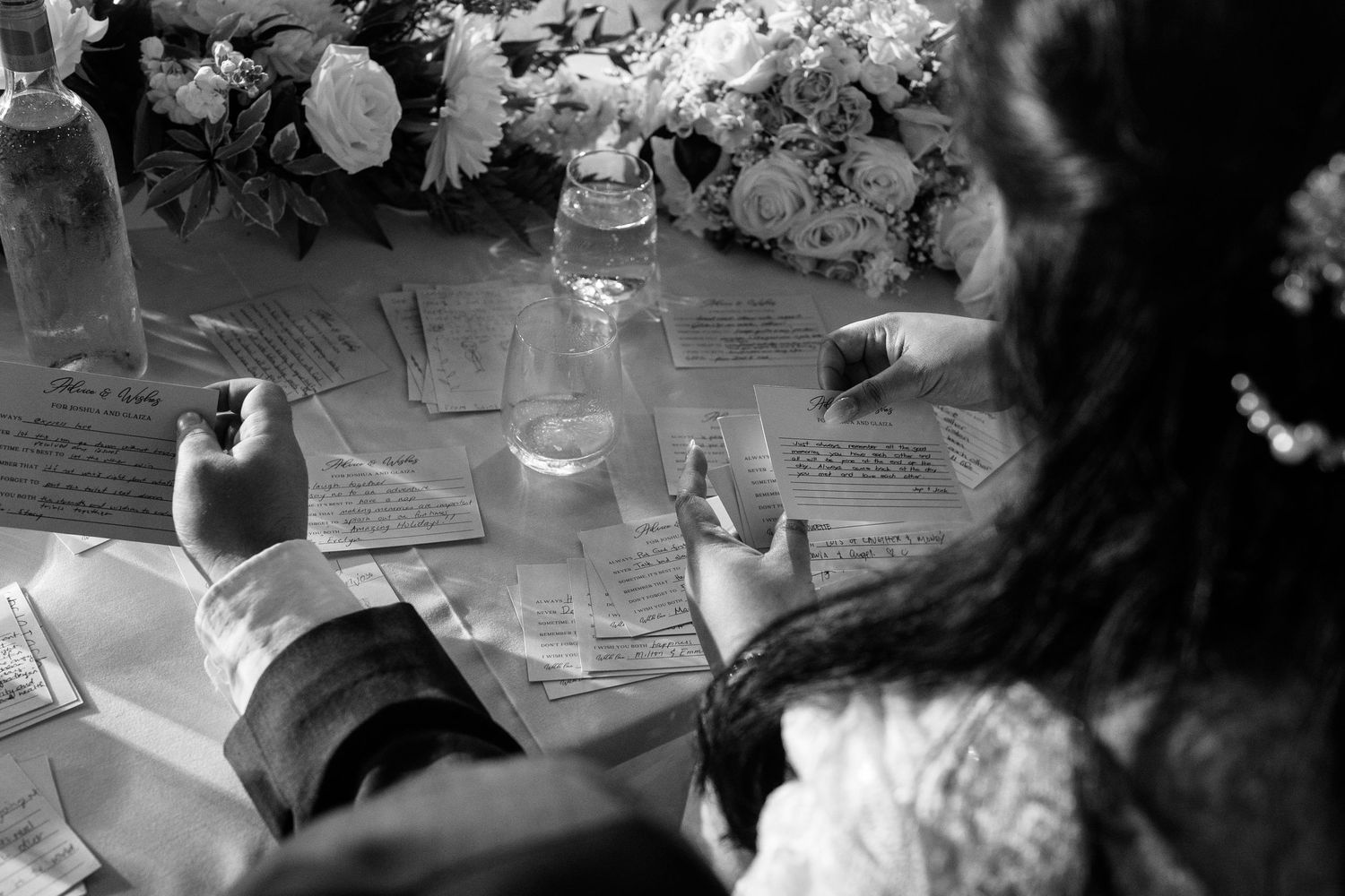 Wedding reception table settings with floral centerpieces in black and white.