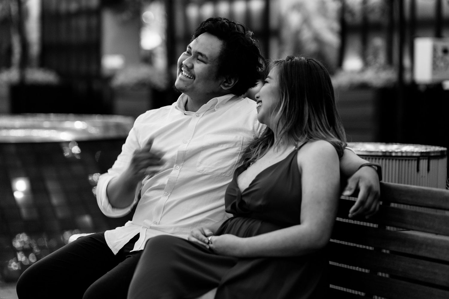 Intimate black and white portrait of couple relaxing on park bench.
