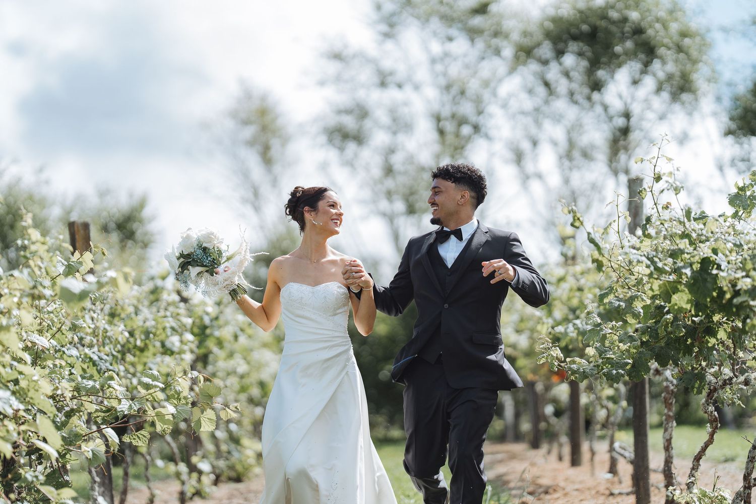 Couple dancing and celebrating in an orchard with white blossoms.